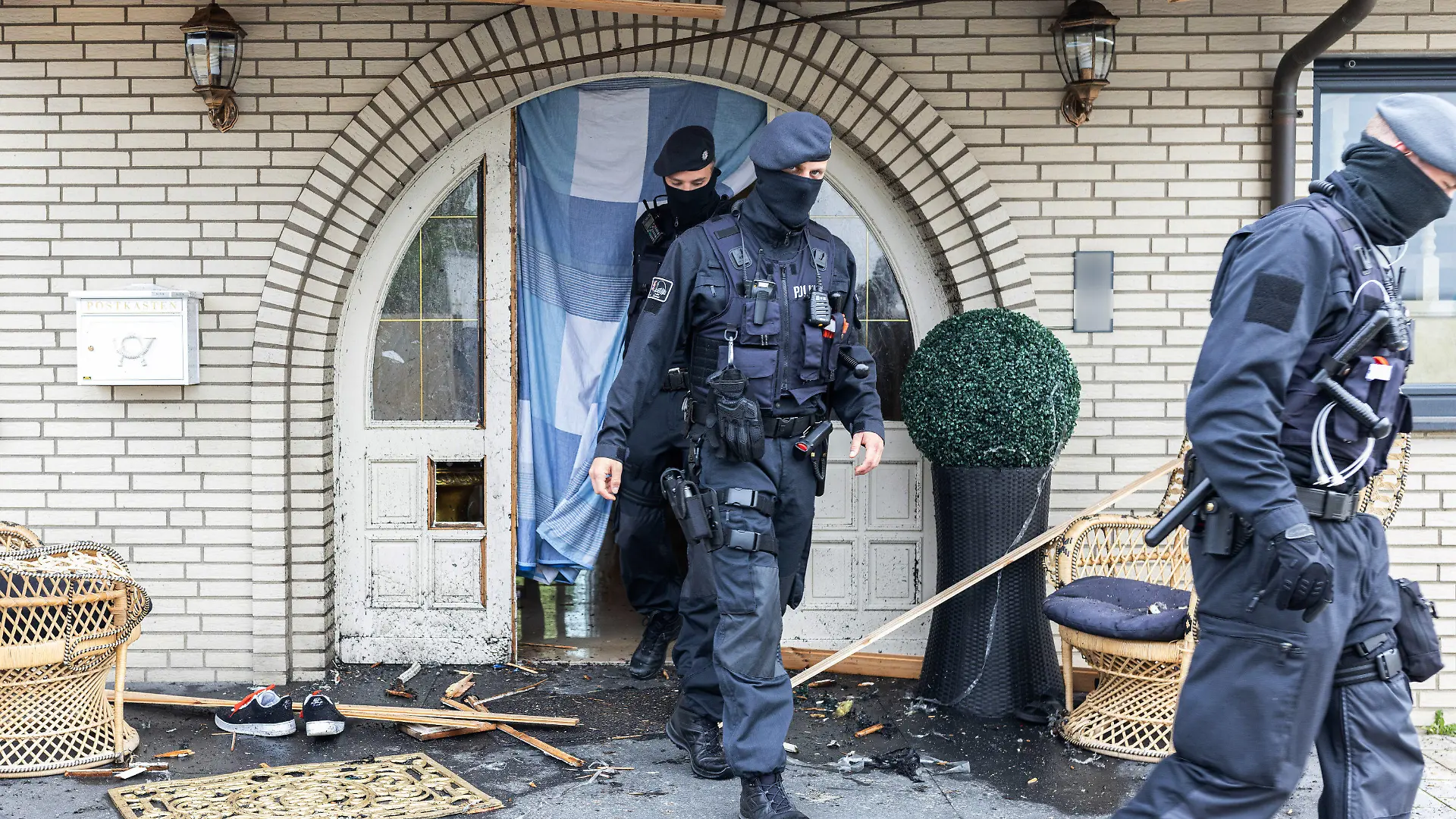 dpatopbilder - 08.06.2021, Nordrhein-Westfalen, Leverkusen: Polizisten verlassen eine Villa. Bei Ermittlungen gegen Clankriminalität durchsuchen derzeit Spezialkräfte der Polizei rund 30 Objekte in Nordrhein-Westfalen. (ACHTUNG: Namensschild an Haustür wurde aus rechtlichen Gründen gepixelt!) Foto: Marcel Kusch/dpa +++ dpa-Bildfunk +++