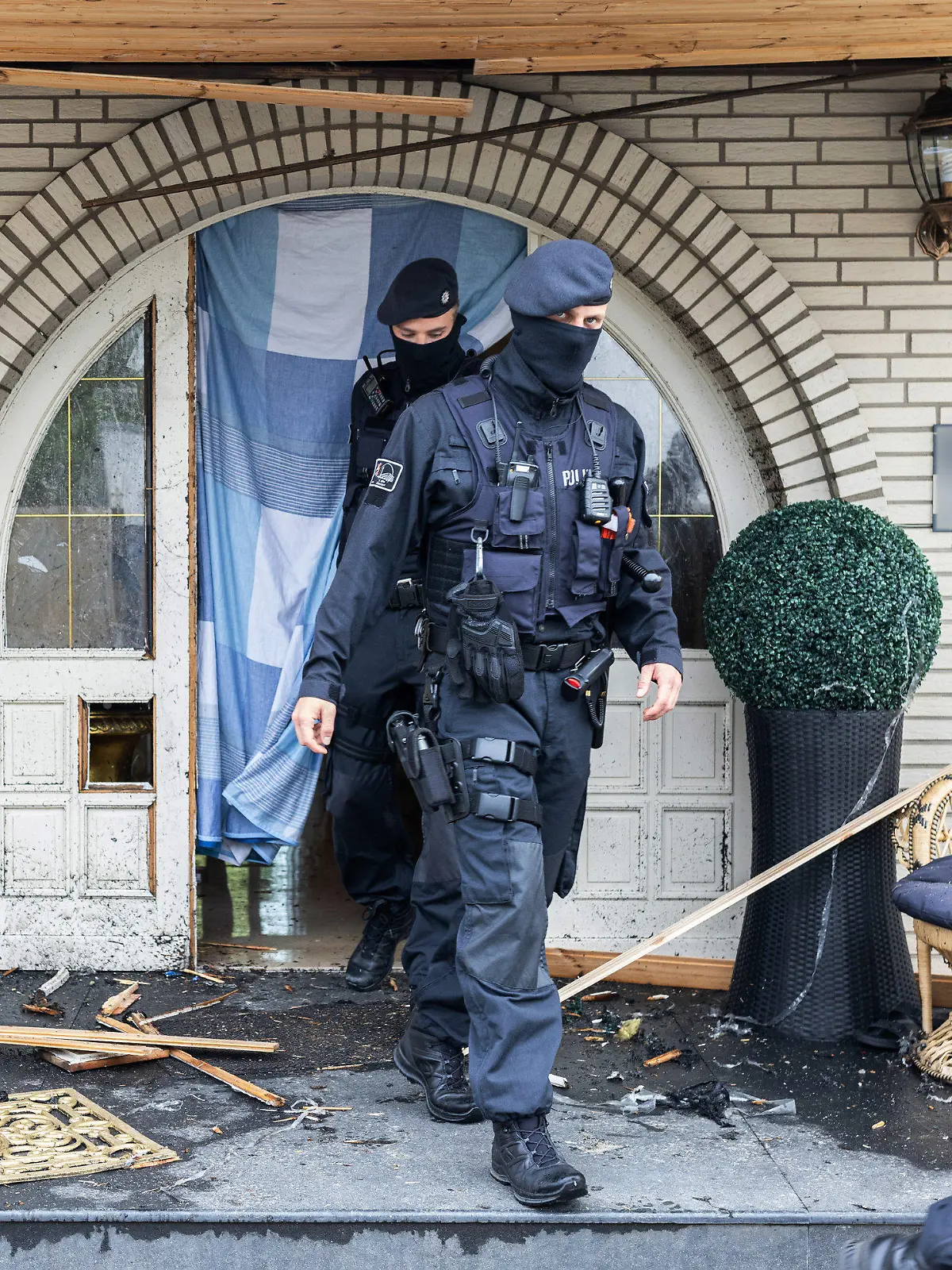 dpatopbilder - 08.06.2021, Nordrhein-Westfalen, Leverkusen: Polizisten verlassen eine Villa. Bei Ermittlungen gegen Clankriminalität durchsuchen derzeit Spezialkräfte der Polizei rund 30 Objekte in Nordrhein-Westfalen. (ACHTUNG: Namensschild an Haustür wurde aus rechtlichen Gründen gepixelt!) Foto: Marcel Kusch/dpa +++ dpa-Bildfunk +++