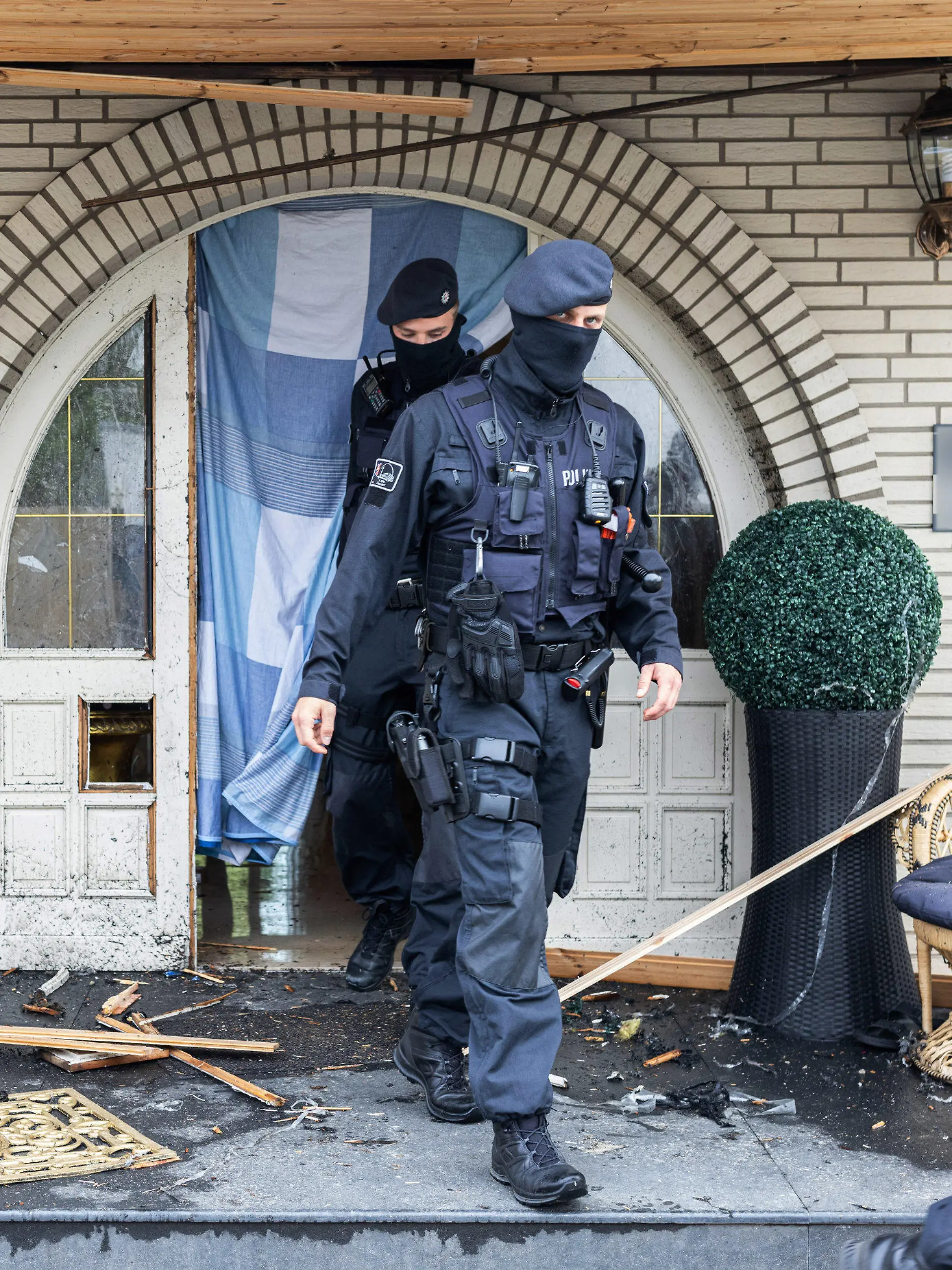 dpatopbilder - 08.06.2021, Nordrhein-Westfalen, Leverkusen: Polizisten verlassen eine Villa. Bei Ermittlungen gegen Clankriminalität durchsuchen derzeit Spezialkräfte der Polizei rund 30 Objekte in Nordrhein-Westfalen. (ACHTUNG: Namensschild an Haustür wurde aus rechtlichen Gründen gepixelt!) Foto: Marcel Kusch/dpa +++ dpa-Bildfunk +++