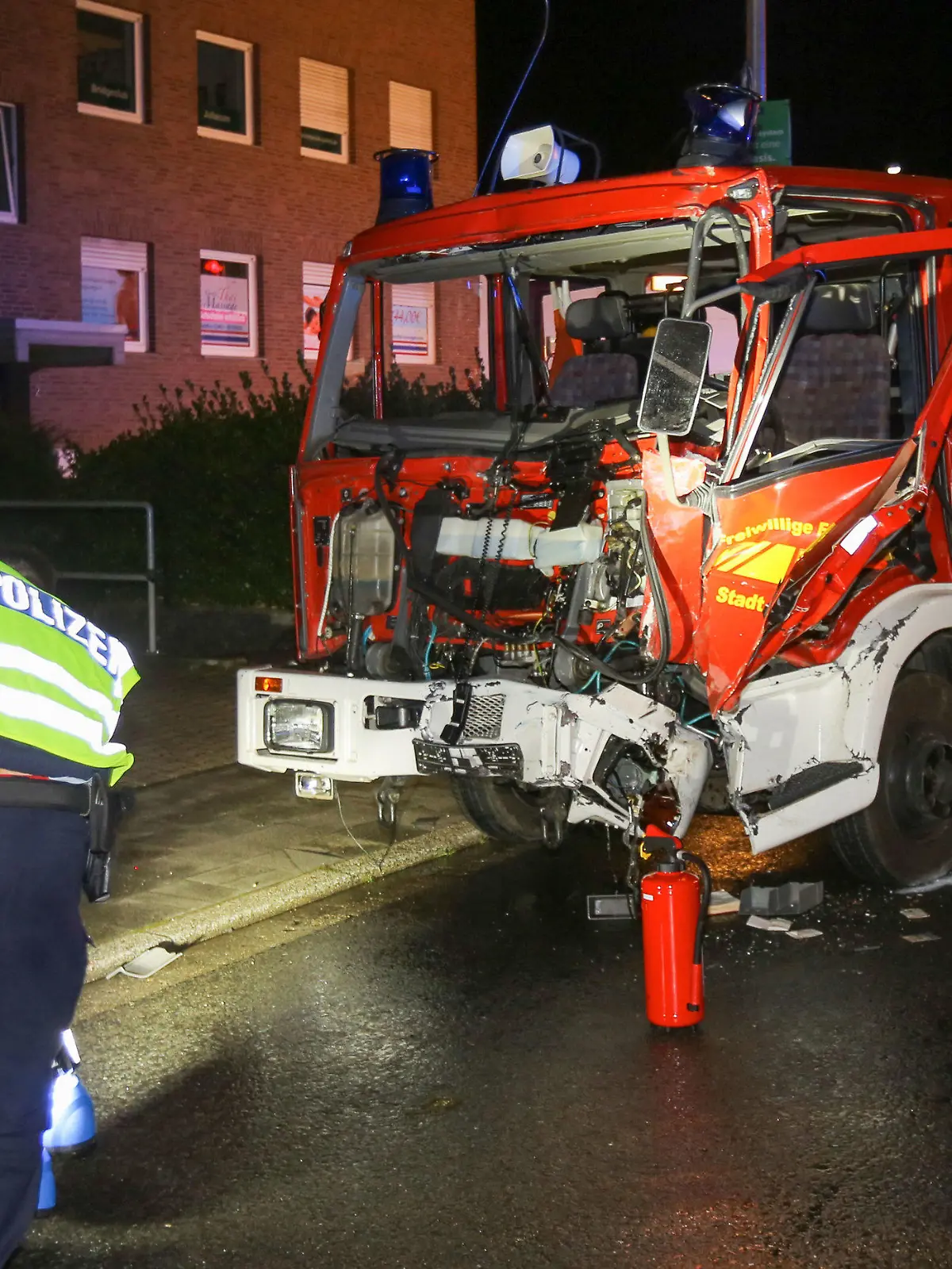 27.09.2021, Nordrhein-Westfalen, Jülich: Polizisten sichern  Spuren vor einem verunfallten Feuerwehrauto. Neun Verletzte, ein zerstörtes Löschfahrzeug, ein ramponiertes Sonnenstudio und Sachschaden in sechsstelliger Höhe: Die Einsatzfahrt eines Feuerwehrfahrzeugs zu einem brennenden Wohnhaus in der nordrhein-westfälischen Kleinstadt Jülich ist am Montagabend nach einer heftig Kollision mit einem mit Zuckerrüben beladenen Lkw vorzeitig zu Ende gegangen. Bei dem Wohnhausbrand im Jülicher Stadtteil Stetternich, zu dem die Feuerwehr unterwegs war, starb ersten Erkenntnissen zufolge ein Mensch. Foto: Ralf Roeger/dmp-press/dpa +++ dpa-Bildfunk +++