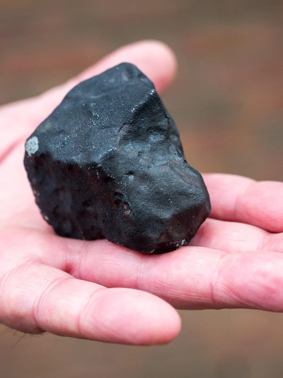 28.04.2023, Schleswig-Holstein, Elmshorn: Ein Hausbesitzer hält vor seinem Haus einen kleinen Meteoriten, der niedergegangen ist. Der Gesteinsbrocken von der Größe eines Tennisballs habe das Dach eines Hauses durchschlagen, dem Deutschen Zentrum für Luft- und Raumfahrt zufolge ist ein solches Ereignis sehr selten. (zu dpa ·Kleiner Meteorit trifft Haus in Schleswig-Holstein·) Foto: Daniel Bockwoldt/dpa/Daniel Bockwoldt +++ dpa-Bildfunk +++