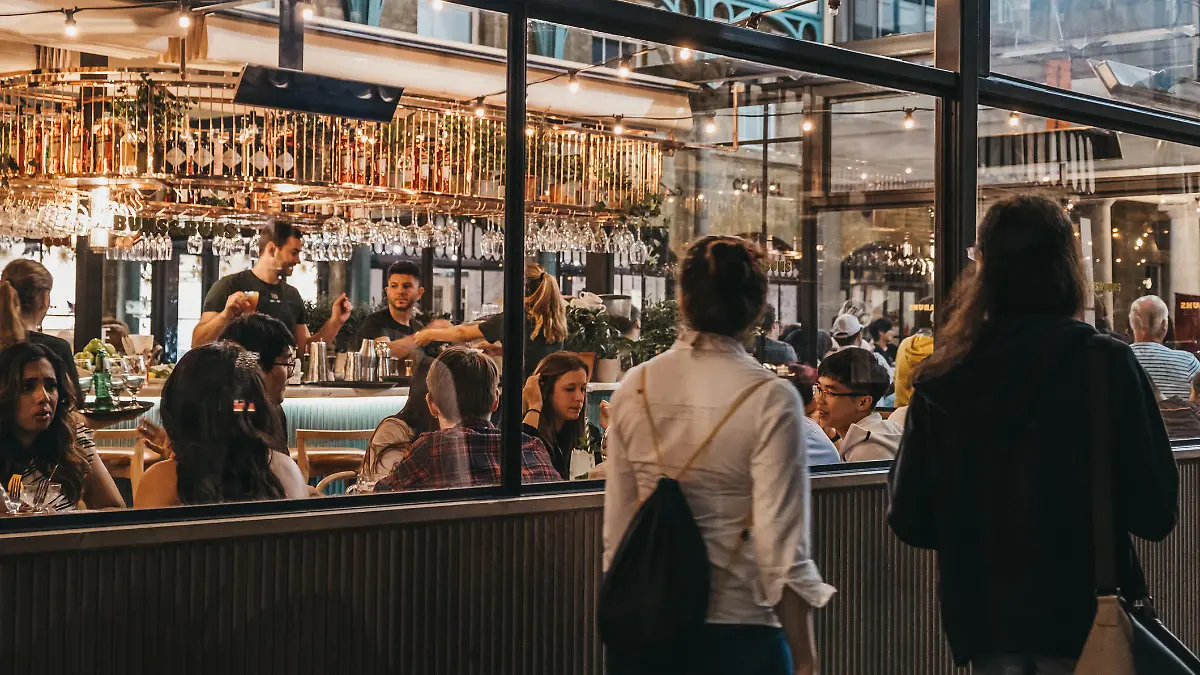London, UK - August 31, 2019: Women walking past the windows of Buns and Buns restaurant in Covent Garden Market, one of the most popular tourist sites in London, UK.