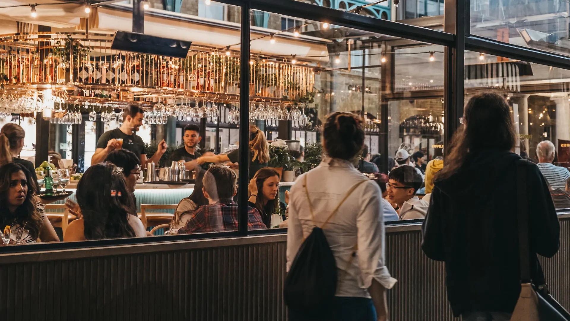 London, UK - August 31, 2019: Women walking past the windows of Buns and Buns restaurant in Covent Garden Market, one of the most popular tourist sites in London, UK.