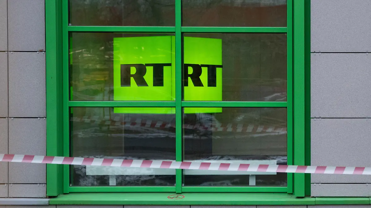 ARCHIV - 27.10.2017, Russland, Moskau: Das Logo des staatlichen russischen TV-Senders «Russia Today» (RT) ist in Fenster des Firmenbüros zu sehen. Die Videoplattform Youtube hat die deutschen Kanäle des russischen Staatsmediums RT gesperrt und entfernt. Ein Youtube-Sprecher bestätigte am Dienstagabend auf Anfrage der Deutschen Presse-Agentur die Kündigung von zwei Kanälen. RT DE berichtete auf der eigenen Webseite ebenfalls über die Sperrung. Die Chefredakteurin von RT mit Sitz in Moskau kritisierte über Twitter den Schritt von Youtube scharf und sprach von einem «Medienkrieg». Foto: Pavel Golovkin/AP/dpa +++ dpa-Bildfunk +++