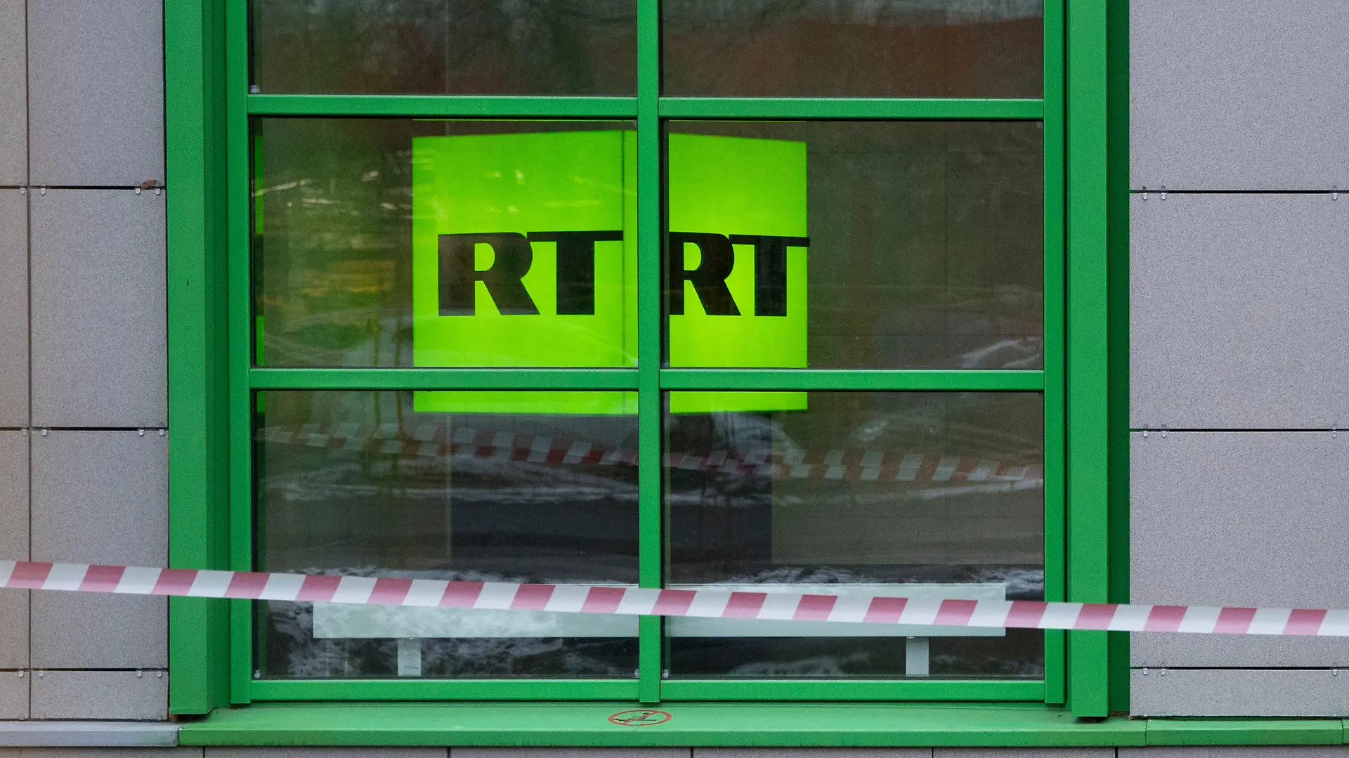 ARCHIV - 27.10.2017, Russland, Moskau: Das Logo des staatlichen russischen TV-Senders «Russia Today» (RT) ist in Fenster des Firmenbüros zu sehen. Die Videoplattform Youtube hat die deutschen Kanäle des russischen Staatsmediums RT gesperrt und entfernt. Ein Youtube-Sprecher bestätigte am Dienstagabend auf Anfrage der Deutschen Presse-Agentur die Kündigung von zwei Kanälen. RT DE berichtete auf der eigenen Webseite ebenfalls über die Sperrung. Die Chefredakteurin von RT mit Sitz in Moskau kritisierte über Twitter den Schritt von Youtube scharf und sprach von einem «Medienkrieg». Foto: Pavel Golovkin/AP/dpa +++ dpa-Bildfunk +++