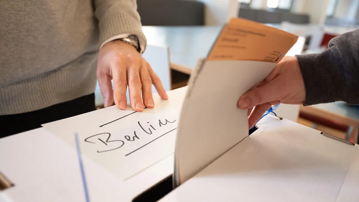 26.09.2021, Berlin: Eine Frau gibt in einem Wahllokal Wahlzettel für die Wahl des Abgeordnetenhauses und den Volksentscheid in Berlin ab. Am 26. September findet die Wahl zum Abgeordntenhaus in Berlin sowie ein Volksentscheid für die Vergesellschaftung von Immobilienbeständen statt. Foto: Sebastian Gollnow/dpa +++ dpa-Bildfunk +++