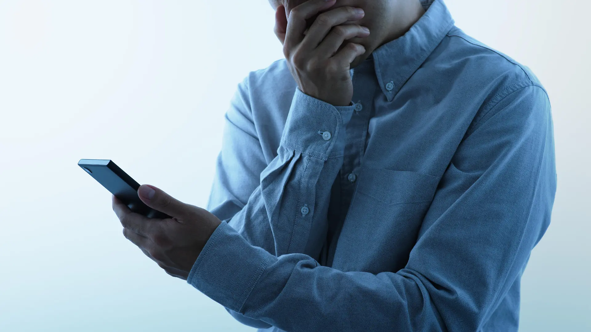 Man seeing smartphone with shocked look.