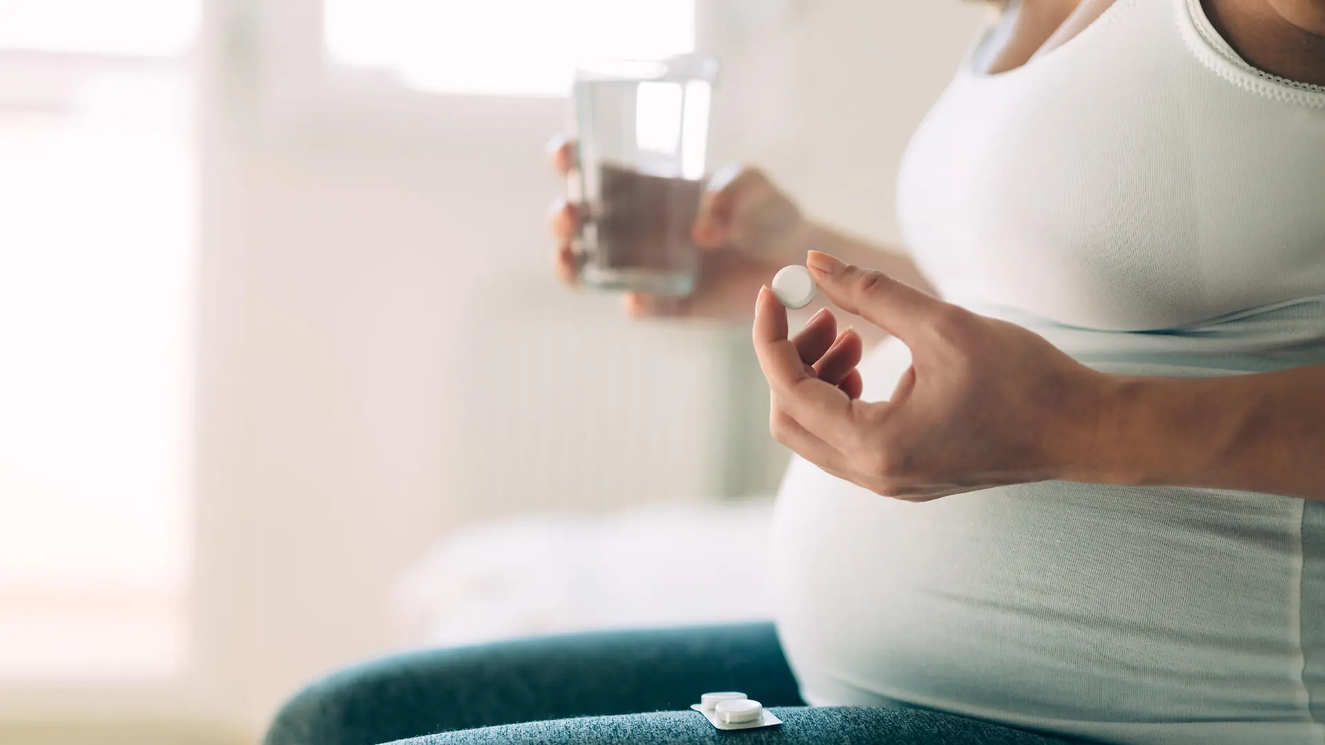 Picture of pregnant woman taking medication pills at home