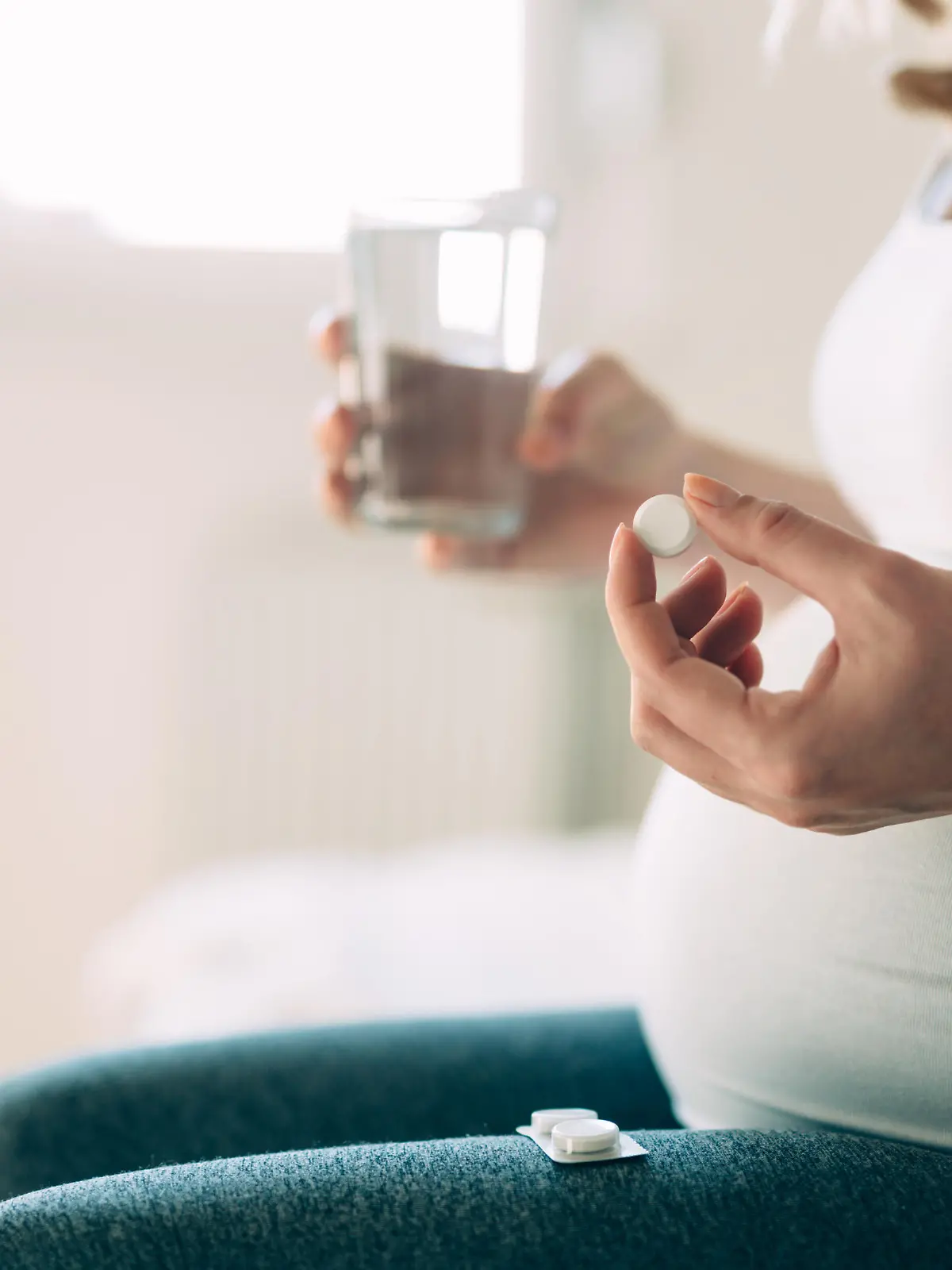 Picture of pregnant woman taking medication pills at home