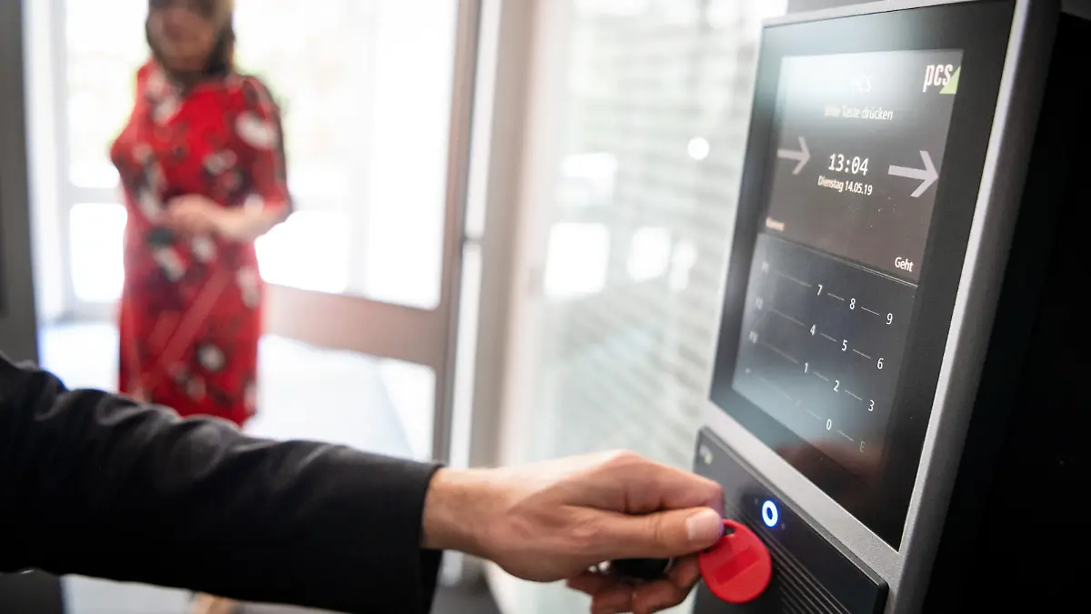 ILLUSTRATION - Ein Mitarbeiter erfasst seine Arbeitszeit digital an einem Terminal. Arbeitgeber sollen verpflichtet werden, die gesamte Arbeitszeit ihrer Beschäftigten systematisch zu erfassen. Das folgt aus einem Urteil des Europäischen Gerichtshofs. Alle EU-Staaten müssten dies durchsetzen, entschieden die obersten EU-Richter am Dienstag in Luxemburg.