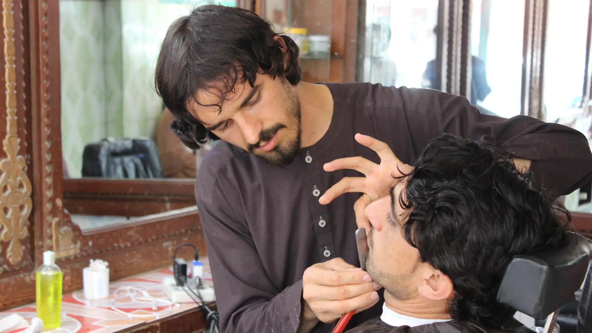 KHOST, AFGHANISTAN - SEPTEMBER 23: A barber cuts shaves beard at a shop in Khost, Afghanistan on September 23, 2021. Barbers in Afghanistan's Khost province say, with the advent of the Taliban, their business has deteriorated and their customers have dwindled. Sardar Shafaq / Anadolu Agency