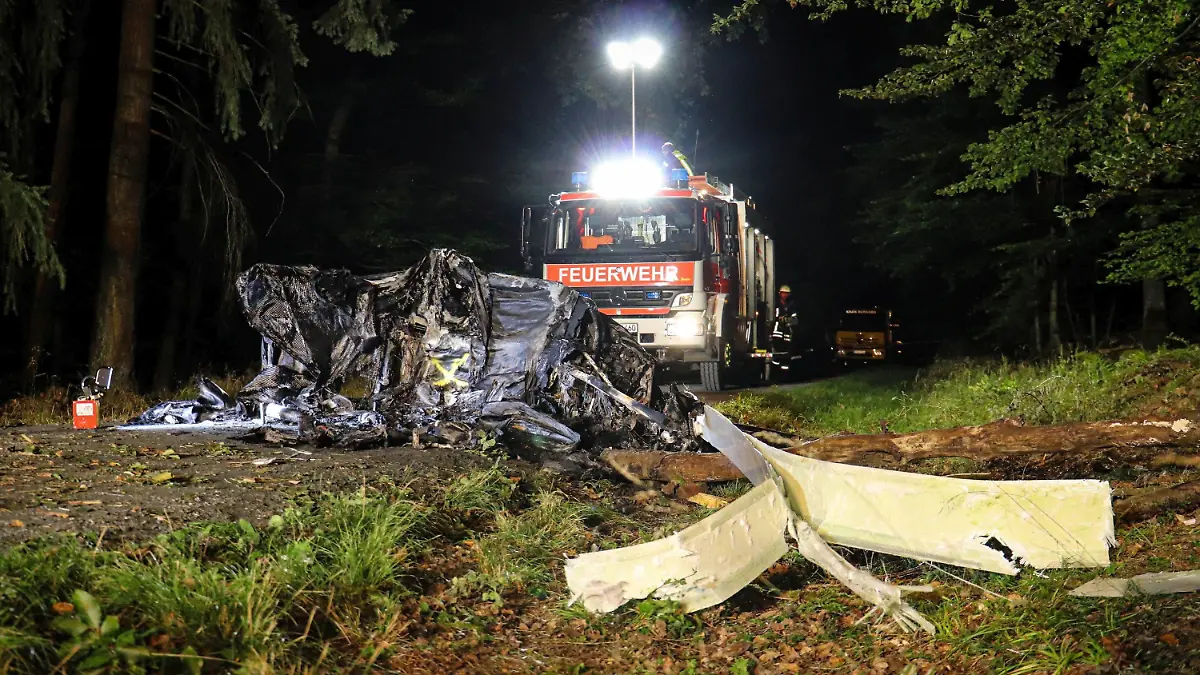 25.09.2021, Hessen, Butzbach: Ein Fahrzeug der Feuerwehr steht hinter einem abgestürzten Tragschrauber. (zu dpa «Zwei Tote bei Absturz eines Tragschraubers») Foto: Fabien Kriegel/5vision media/dpa +++ dpa-Bildfunk +++