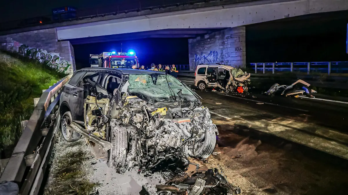 26.09.2021, Baden-Württemberg, Pforzheim: Feuerwehrleute stehen am Unfallort. Drei Menschen sind am frühen Sonntagmorgen bei einem Unfall auf der Autobahn 8 bei Pforzheim ums Leben gekommen, darunter der 35 Jahre alte Unfallverursacher. Der Mann war nach Angaben der Polizei mit seinem Wagen von einem Parkplatz aus entgegen der Fahrtrichtung auf die Autobahn aufgefahren. Dort prallte das Auto (l) frontal in einen anderen Wagen (hinten r): Zwei der Insassen dieses Wagens starben, zwei weitere wurden schwer verletzt. Foto: Alexander Hald/VMD-Images/dpa +++ dpa-Bildfunk +++