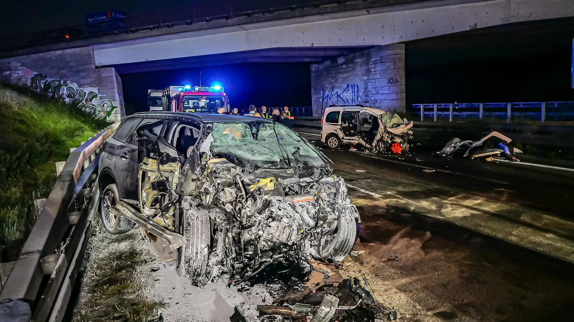 26.09.2021, Baden-Württemberg, Pforzheim: Feuerwehrleute stehen am Unfallort. Drei Menschen sind am frühen Sonntagmorgen bei einem Unfall auf der Autobahn 8 bei Pforzheim ums Leben gekommen, darunter der 35 Jahre alte Unfallverursacher. Der Mann war nach Angaben der Polizei mit seinem Wagen von einem Parkplatz aus entgegen der Fahrtrichtung auf die Autobahn aufgefahren. Dort prallte das Auto (l) frontal in einen anderen Wagen (hinten r): Zwei der Insassen dieses Wagens starben, zwei weitere wurden schwer verletzt. Foto: Alexander Hald/VMD-Images/dpa +++ dpa-Bildfunk +++