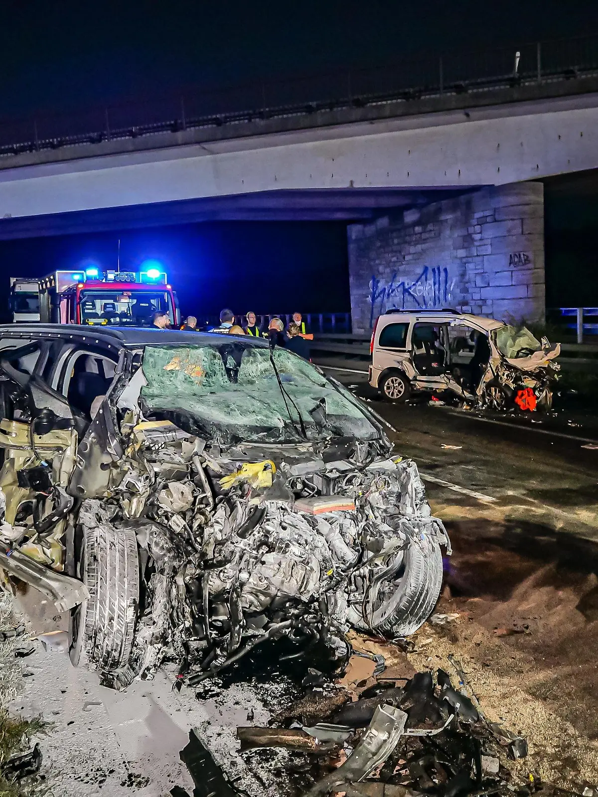 26.09.2021, Baden-Württemberg, Pforzheim: Feuerwehrleute stehen am Unfallort. Drei Menschen sind am frühen Sonntagmorgen bei einem Unfall auf der Autobahn 8 bei Pforzheim ums Leben gekommen, darunter der 35 Jahre alte Unfallverursacher. Der Mann war nach Angaben der Polizei mit seinem Wagen von einem Parkplatz aus entgegen der Fahrtrichtung auf die Autobahn aufgefahren. Dort prallte das Auto (l) frontal in einen anderen Wagen (hinten r): Zwei der Insassen dieses Wagens starben, zwei weitere wurden schwer verletzt. Foto: Alexander Hald/VMD-Images/dpa +++ dpa-Bildfunk +++