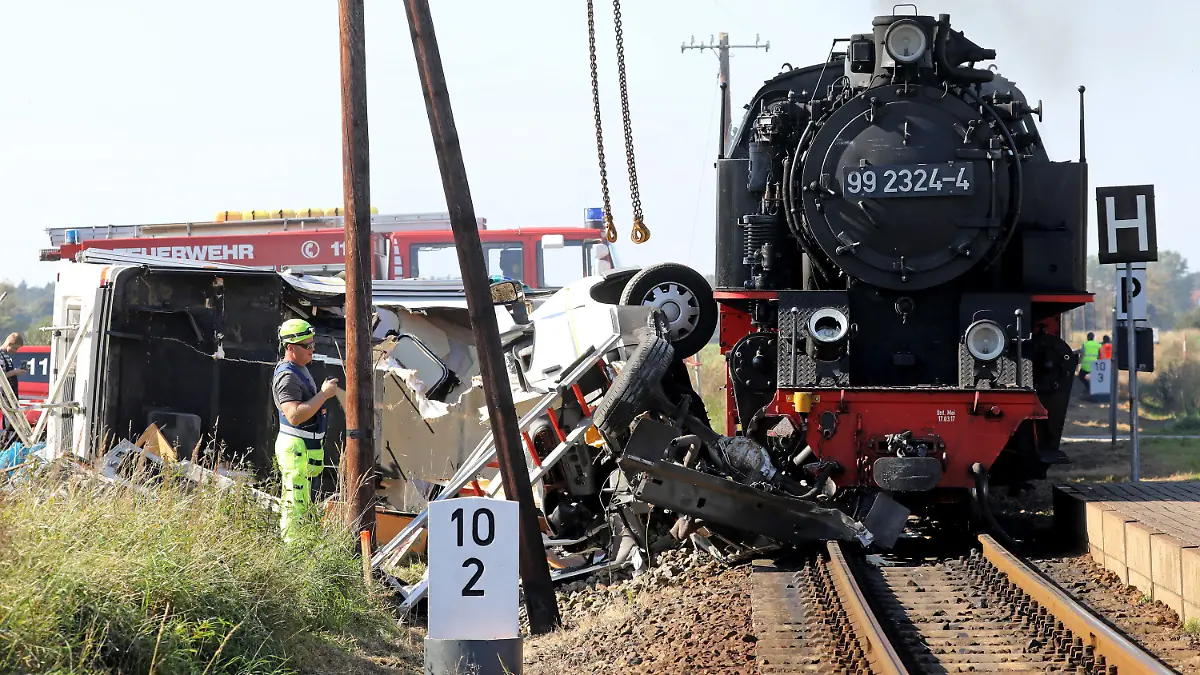 26.09.2021, Mecklenburg-Vorpommern, Wittenbeck: Nach der Kollision der Kleinbahn Molli mit einem Wohnmobil erfolgen die Bergungsarbeiten für die Fahrzeuge. Bei dem Unfall wurden die beiden Insassen des Wohnmobils schwer verletzt. Das Wohnmobil wurde etwa 50 Meter mitgeschleift und in zwei Teile zerrissen. Foto: Bernd Wüstneck/dpa-Zentralbild/dpa +++ dpa-Bildfunk +++