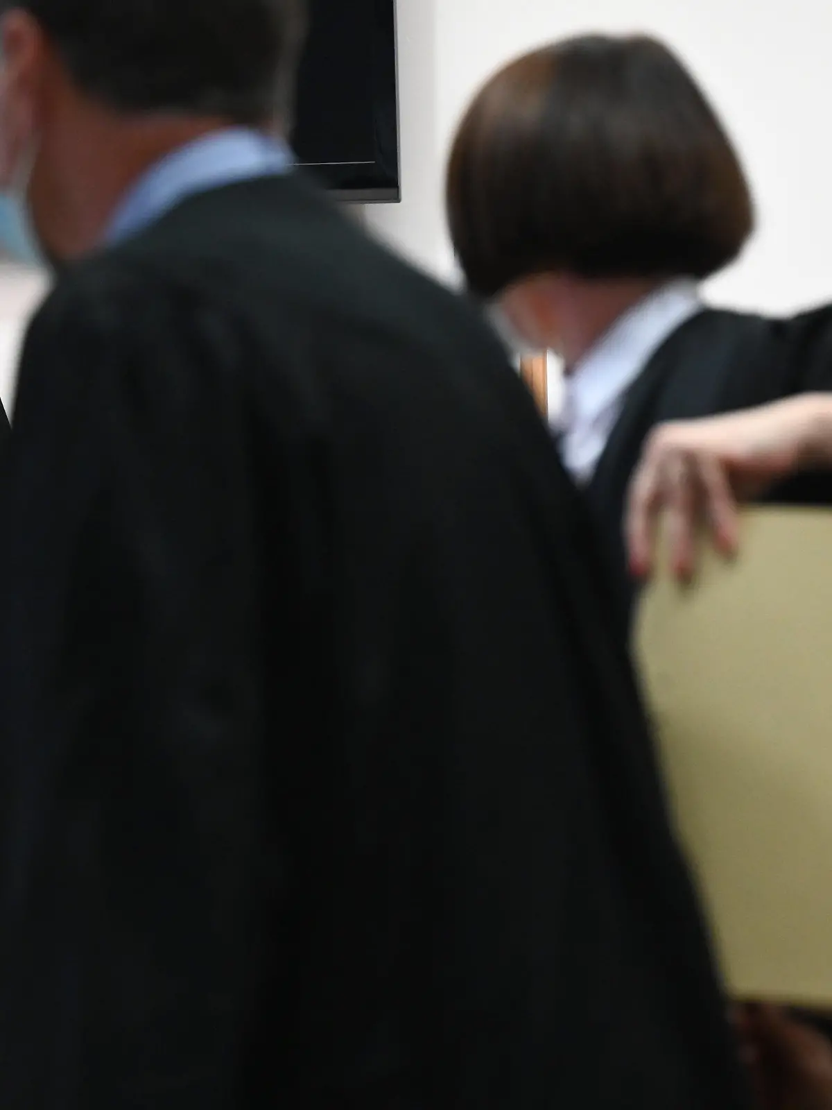 14.09.2021, Hessen, Hanau: Susanne Wetzel (l), Vorsitzende Richterin und Präsidentin am Landgericht Hanau, eröffnet im Gerichtssaal des Landgerichts den Prozess gegen eine 60-jährige Frau (r), die zusammen mit ihren Verteidigern Thomas Scherzberg und Wiebke Otto-Hanschmann auf der Anklagebank Platz genommen hat. Die Staatsanwaltschaft Hanau hatte wegen gemeinschaftlichen Mordes Anklage gegen die Frau erhoben. Ihr wird vorgeworfen, ihren vierjährigen Sohn am 17. August 1988 aus niedrigen Beweggründen getötet zu haben. Sie soll ihr Kind in einem verschnürten Sack in die Obhut einer bereits im September 2020 verurteilten mutmaßlichen Sekten-Chefin gegeben haben, die dem Kind nach dem Leben getrachtet haben soll. Foto: Arne Dedert/dpa +++ dpa-Bildfunk +++