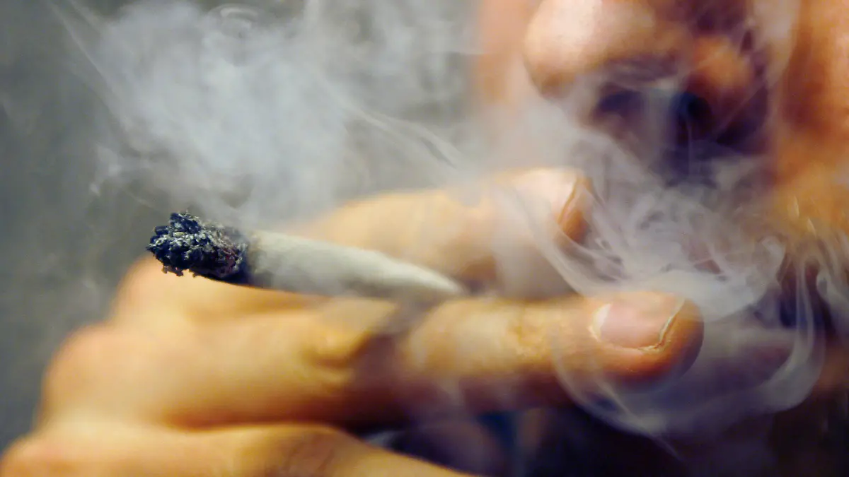 ARCHIV - 30.11.2006, Bayern, Würzburg: Ein Mann raucht einen Joint mit Marihuana. Der Konsum von Tabak, Alkohol und illegalen Drogen ist in Deutschland nach wie vor zu groß. (zu dpa "Jahrbuch Sucht: zu viel Tabak, Alkohol und illegale Drogen" vom 28.03.2018) Foto: Daniel Karmann/dpa +++ dpa-Bildfunk +++