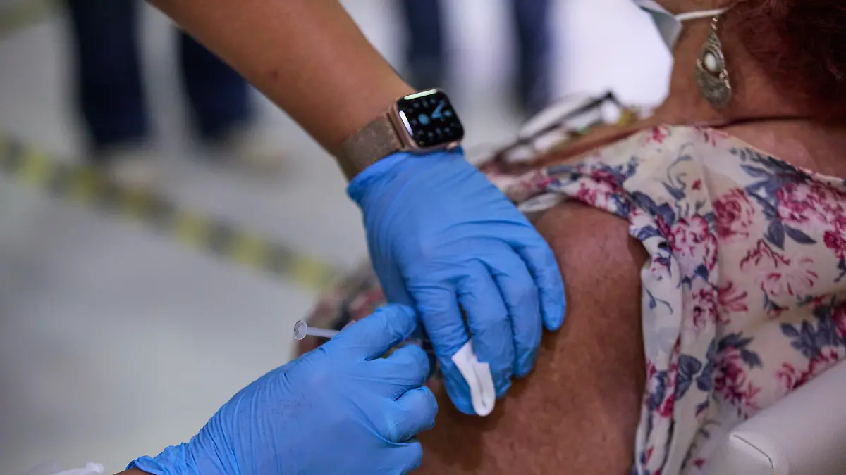 22.09.2021, Spanien, Madrid: Eine Frau erhält die dritte Dosis des Corona-Impfstoffs in der Seniorenresidenz Vista Alegre in Madrid. In Spanien wird älteren Menschen, die in Altersheimen leben, und Personen aus der Risikogruppe eine dritte Dosis des Corona-Impfstoffs verabreicht. Foto: Jesús Hellín/EUROPA PRESS/dpa +++ dpa-Bildfunk +++