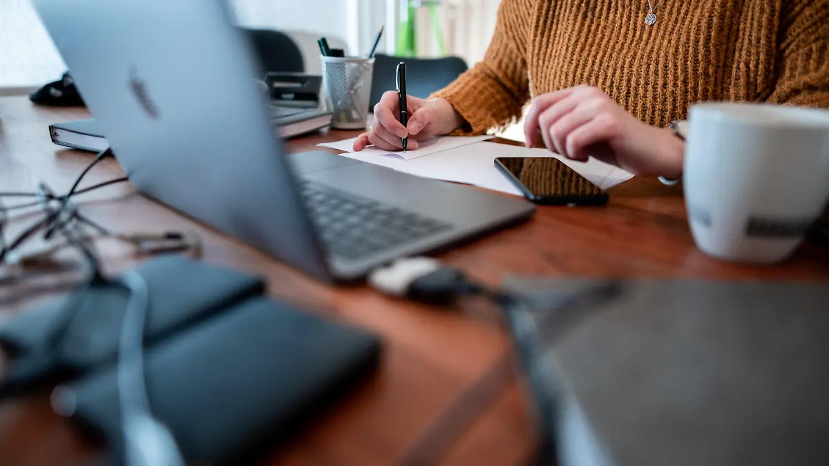 ILLUSTRATION - 19.01.2021, Nordrhein-Westfalen, Oberhausen: ARCHIV - Eine Frau sitzt mit einem Laptop an einem Tisch im Homeoffice. Der Deutsche Beamtenbund in Nordrhein-Westfalen fordert für den öffentlichen Dienst klare gesetzliche Regelungen für das Arbeiten von zuhause aus (zu dpa «Beamte fordern Homeoffice-Regeln - Justizminister: «kein Notbetrieb»» vom 22.1.2021). Foto: Fabian Strauch/dpa +++ dpa-Bildfunk +++