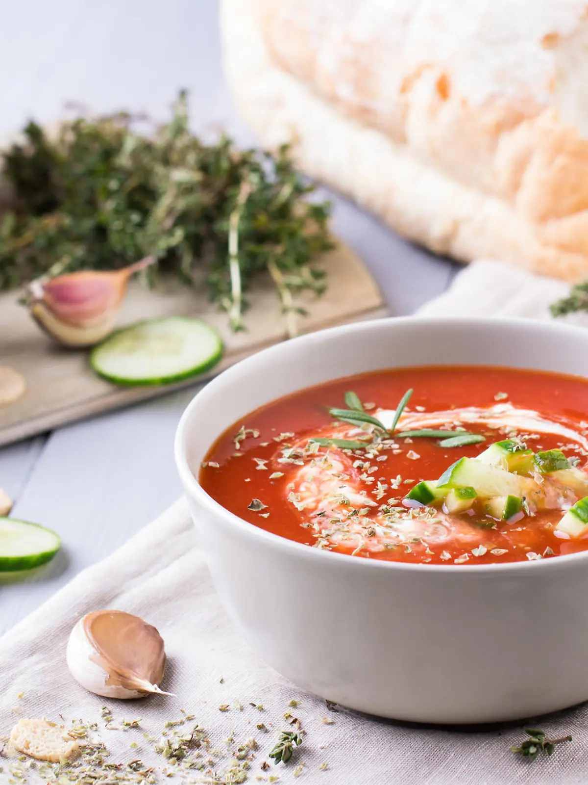 fresh tomato soup in a grey bowl. Traditional spanish soup gazpacho with herbs, little croutons, pepper and fresh cucumbers.