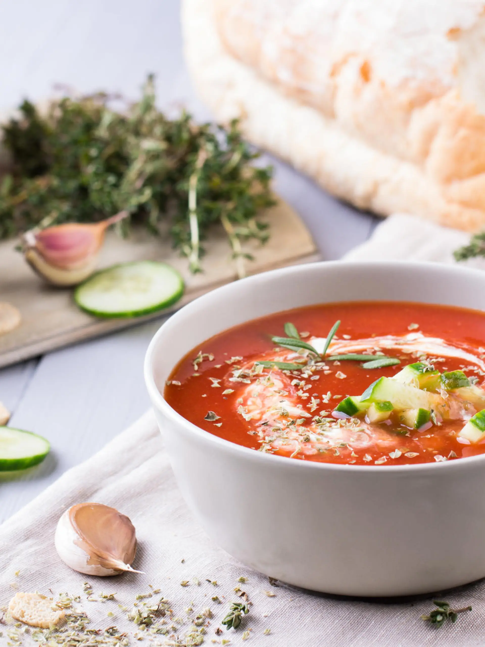 fresh tomato soup in a grey bowl. Traditional spanish soup gazpacho with herbs, little croutons, pepper and fresh cucumbers.