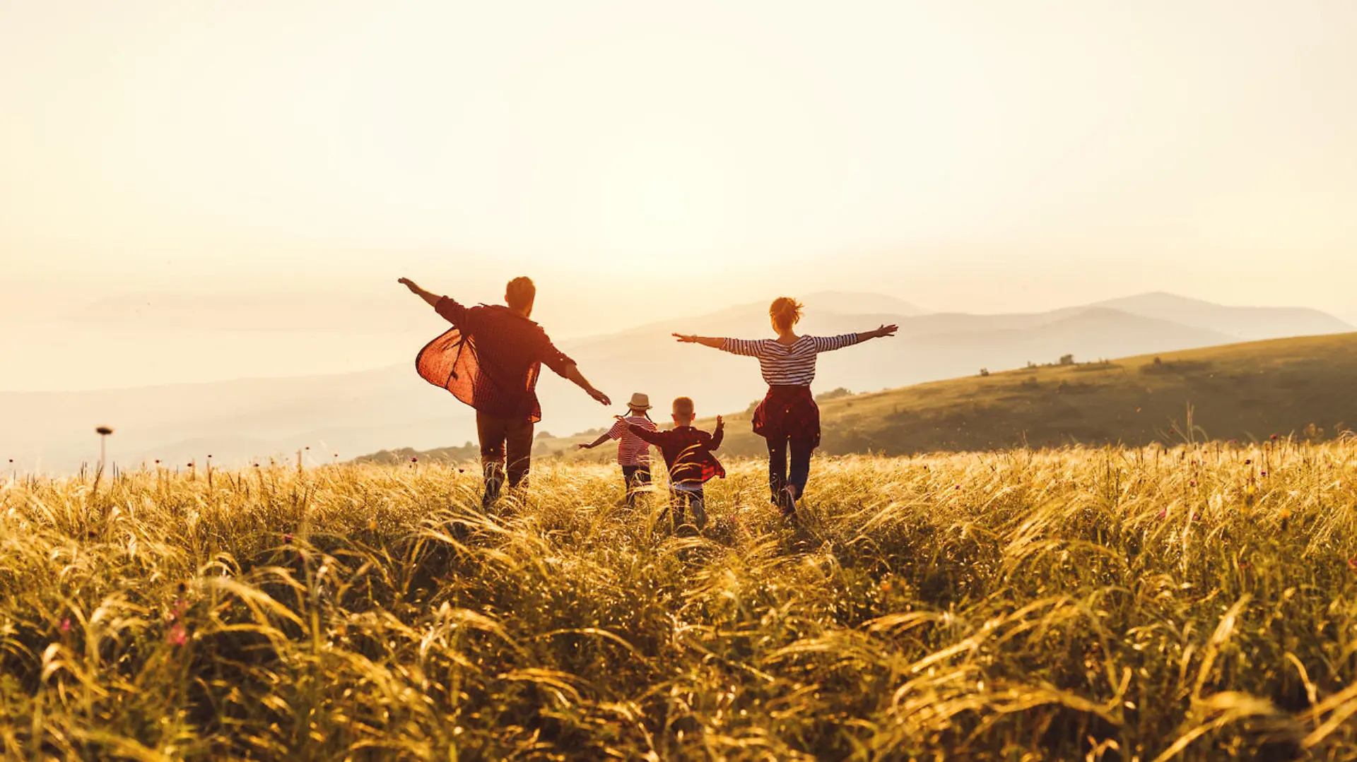 Happy family: mother, father, children son and daughter runing and jumping on nature on sunset