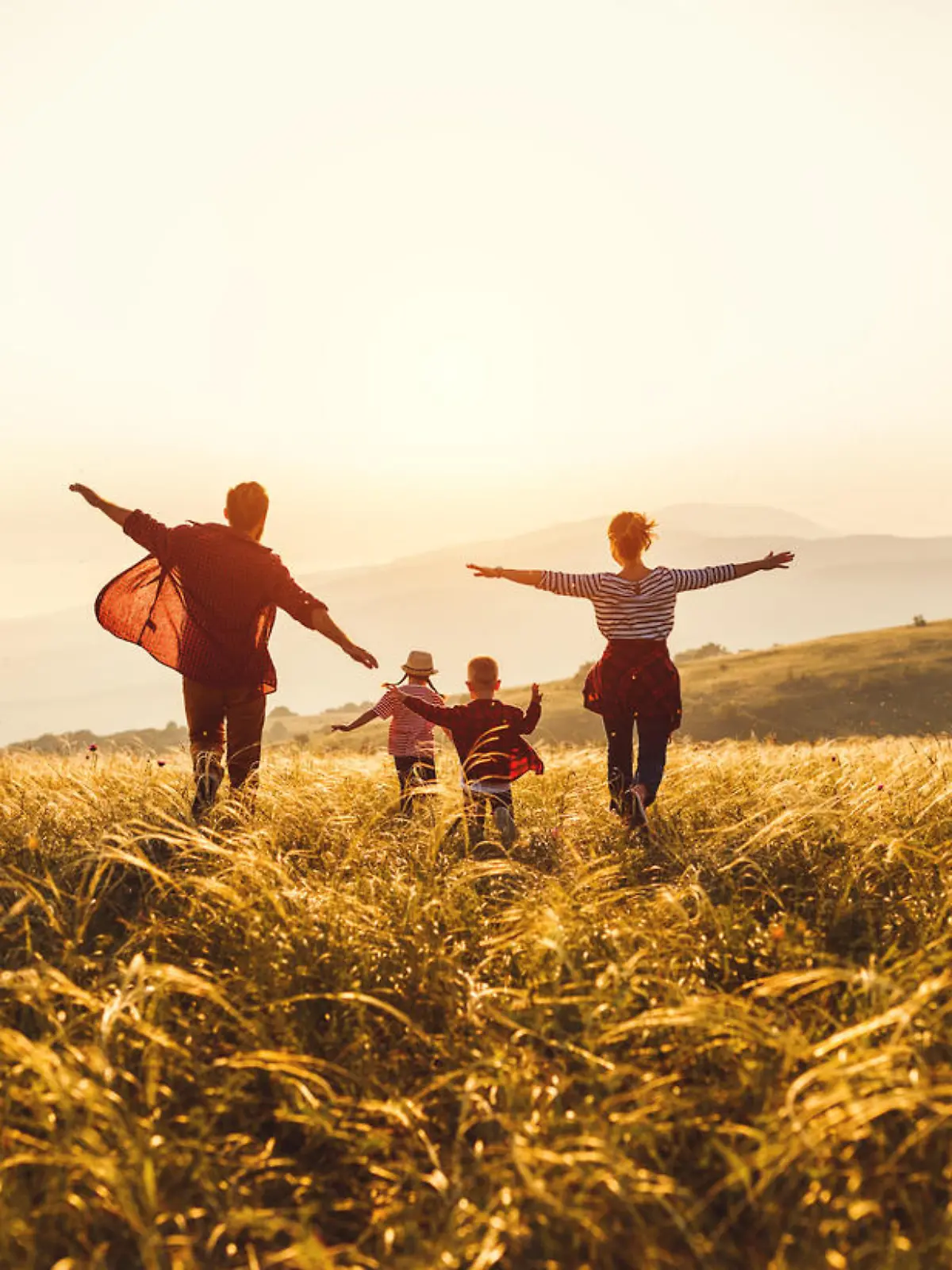 Happy family: mother, father, children son and  daughter runing and jumping on nature  on sunset