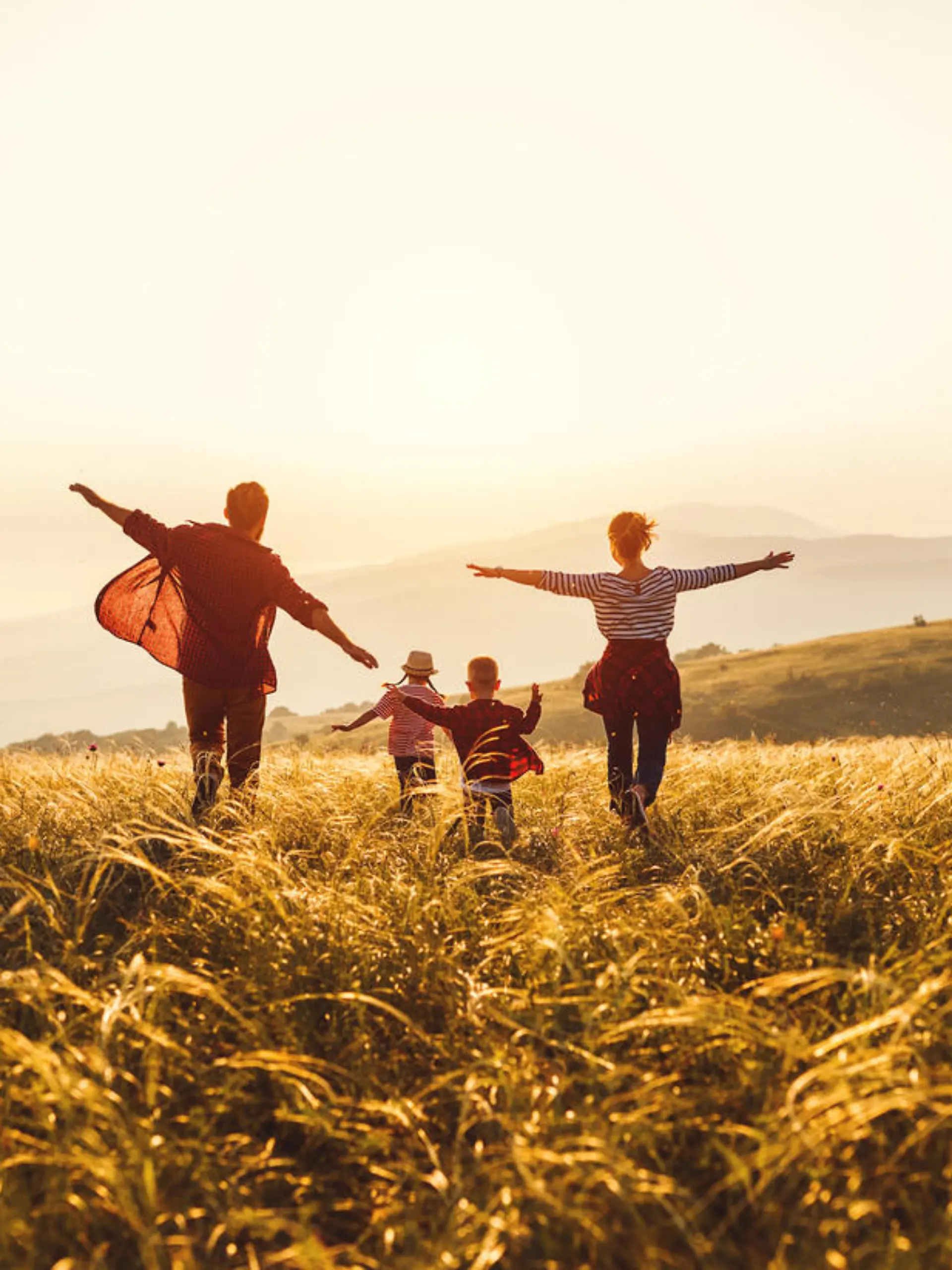 Happy family: mother, father, children son and  daughter runing and jumping on nature  on sunset