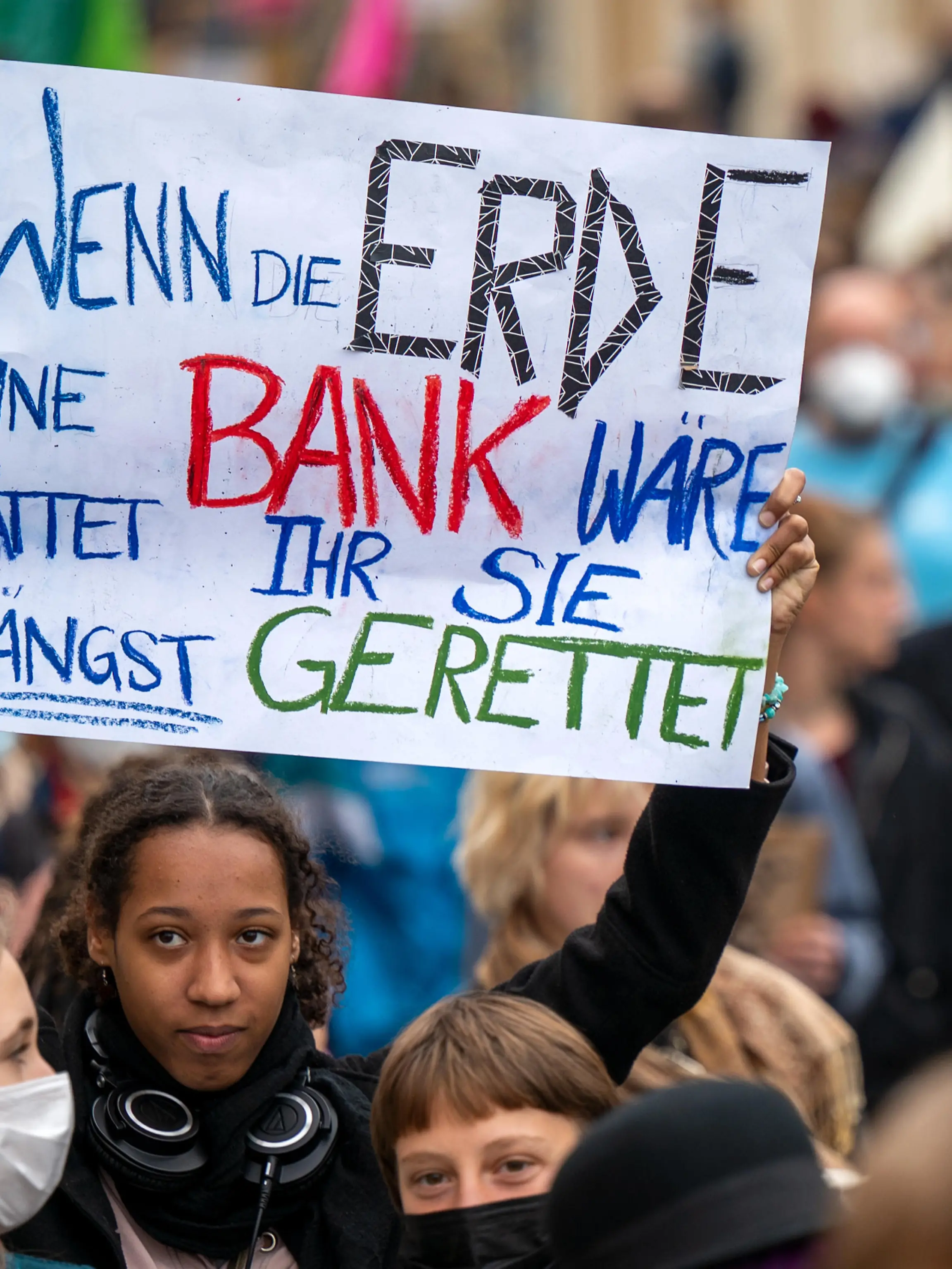 Eine Teilnehmerin trägt bei einer Kundgebung von „Fridays for Future“ in der Potsdamer Innenstadt ein Schild mit der Aufschrift „Wenn die Erde eine Bank wäre hättet ihr sie längst gerettet“.