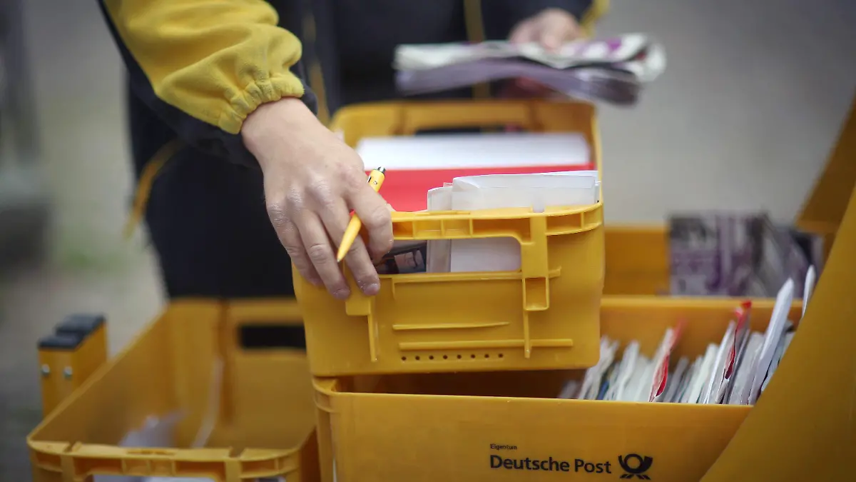 ARCHIV - Ein Mitarbeiter der Deutschen Post entnimmt am 09.06.2015 in Idstein (Hessen) Briefe aus seinem Briefzustellerwagen. Der unbefristete Streik bei der Post geht in die dritte Woche. Foto: Fredrik von Erichsen/dpa (zu Vorausmeldung «Kein Ende des Post-Streiks in Sicht» vom 21.06.2015) +++(c) dpa - Bildfunk+++