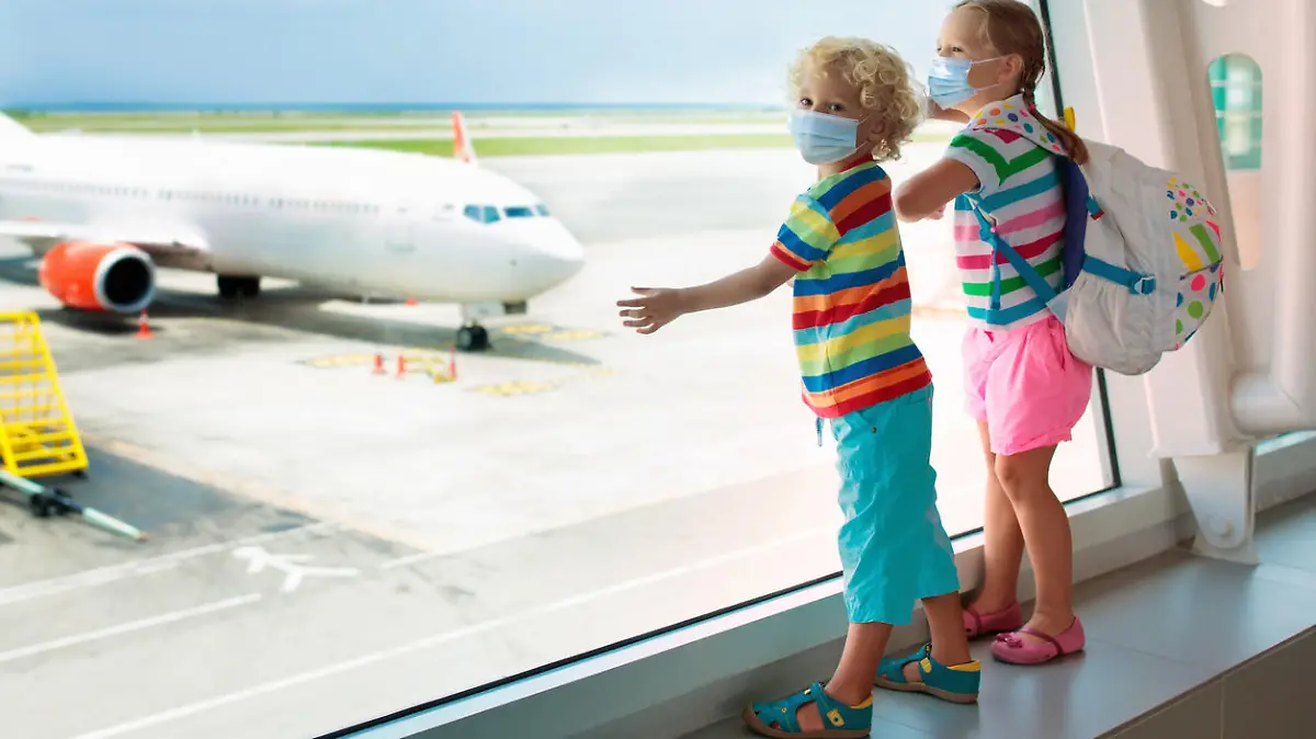 Family in airport in face mask. Virus outbreak. Coronavirus and flu pandemic. Safe travel with young child and baby. Kids boarding airplane in surgical masks.