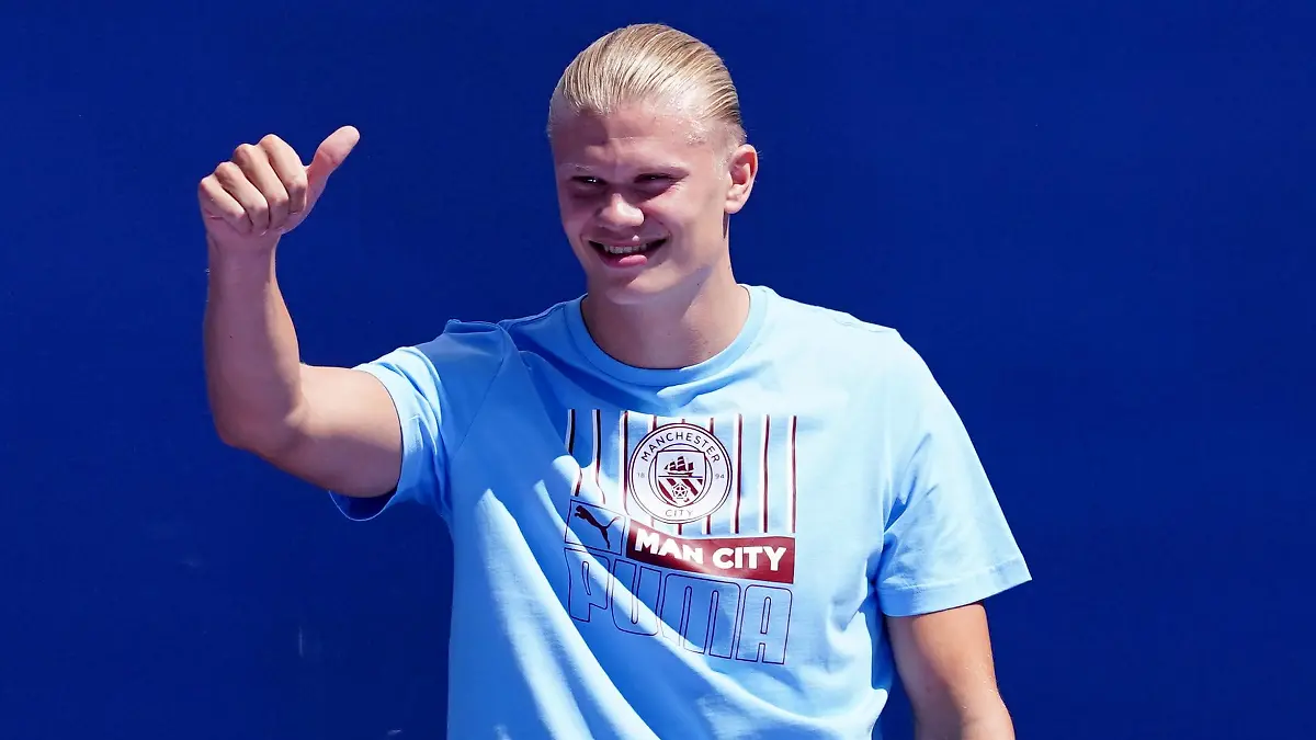 10.07.2022, Großbritannien, Manchester: Erling Haaland, Neuzugang bei Manchester City, zeigt bei der Präsentation der Neuverpflichtungen im Etihad Stadium seinen Daumen. Haaland wird beim englischen Fußball-Meister Manchester City wie zuvor bei Borussia Dortmund die Nummer 9 tragen. Foto: Martin Rickett/PA Wire/dpa +++ dpa-Bildfunk +++