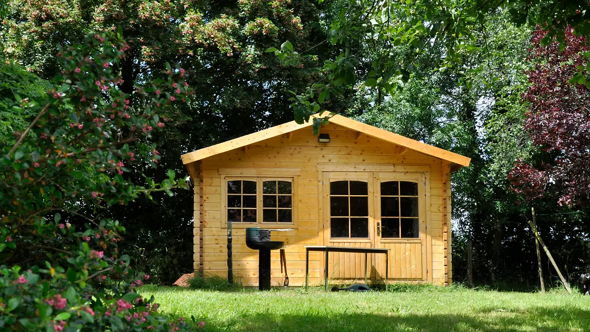 Front view of an Iconic barbecue set up in front of a wooden cabin in the garden