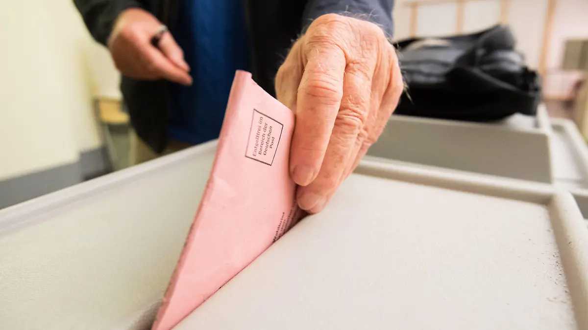 PRODUKTION - 23.08.2021, Niedersachsen, Hannover: Ein Mann wirft seinen Stimmzettel für die Bundestagswahl in eine Urne im Neuen Rathaus. (zu dpa "So funktioniert die Bundestagswahl") Foto: Julian Stratenschulte/dpa +++ dpa-Bildfunk +++