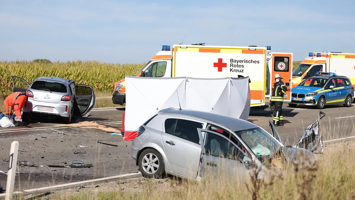 Nach einem Frontalzusammenstoß stehen zwei Autos und mehrere Rettungsfahrzeuge auf einer Bundesstraße. Drei Menschen sind bei dem Verkehrsunfall auf der Bundesstraße 2 in Mittelfranken ums Leben gekommen.