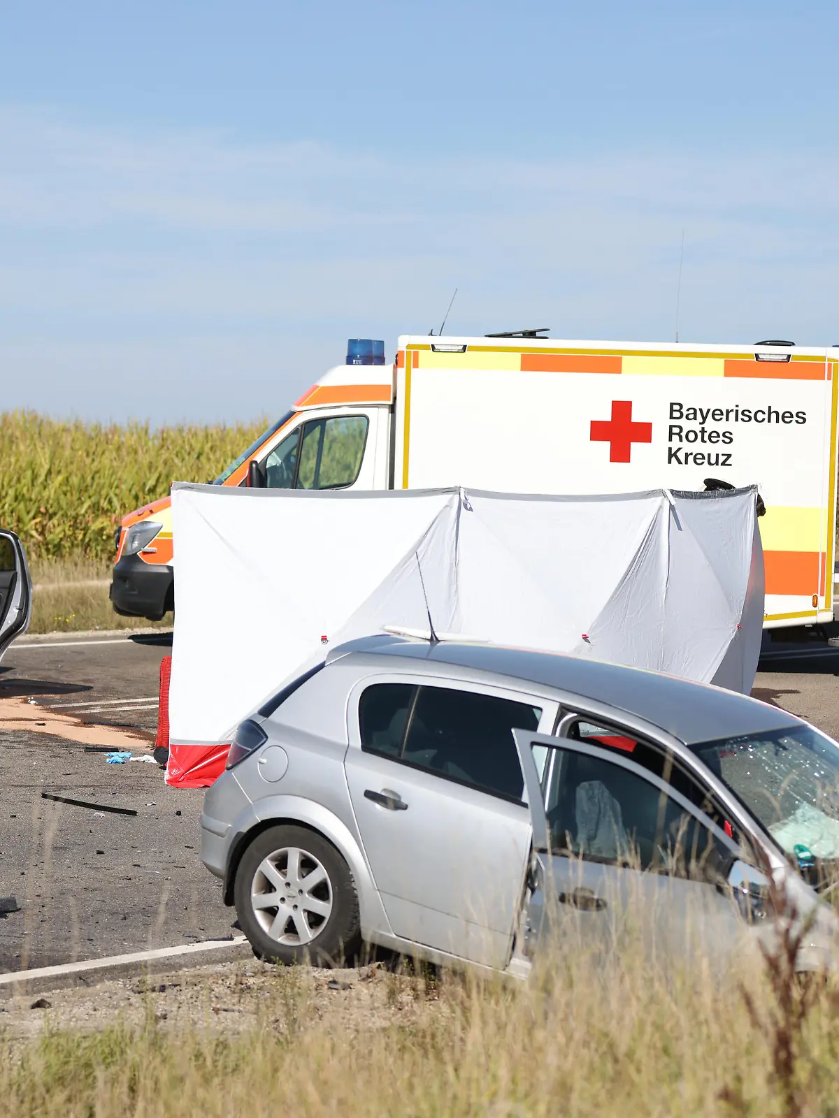 Nach einem Frontalzusammenstoß stehen zwei Autos und mehrere Rettungsfahrzeuge auf einer Bundesstraße. Drei Menschen sind bei dem Verkehrsunfall auf der Bundesstraße 2 in Mittelfranken ums Leben gekommen.