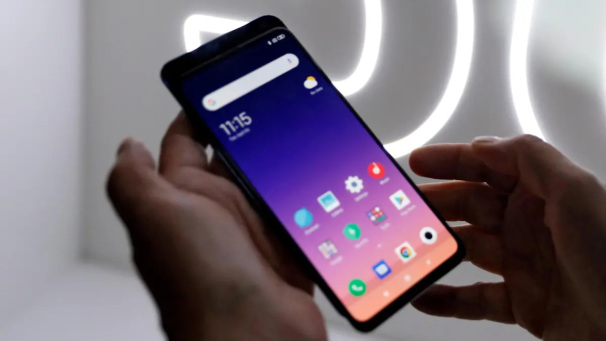 FILE PHOTO: FILE PHOTO: A person checks out the new Xiaomi Mi 9 mobile phone ahead of the Mobile World Congress (MWC 19) in Barcelona, Spain, February 24, 2019. REUTERS/Rafael Marchante/File Photo/File Photo