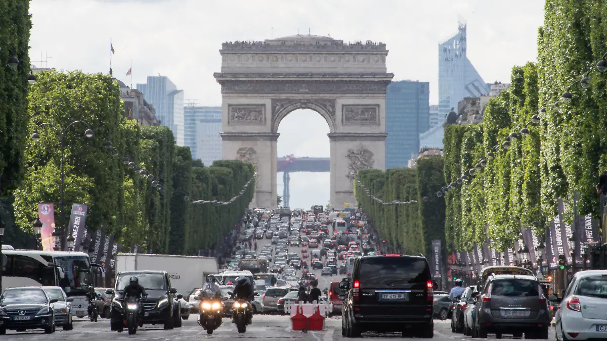 ARCHIV - 02.07.2016, Frankreich, Paris: Autos fahren über die Champs-Elysees unweit des Arc de Triomphe. Mit Ausnahme der großen Verkehrsachsen und des Stadtrings Périphérique sollen Autos in Frankreichs Hauptstadt nur noch maximal 30 Stundenkilometer schnell fahren dürfen. Andere Städte in Frankreich haben bereits ähnliche Geschwindigkeitsbeschränkungen eingeführt. Foto: Peter Kneffel/dpa +++ dpa-Bildfunk +++