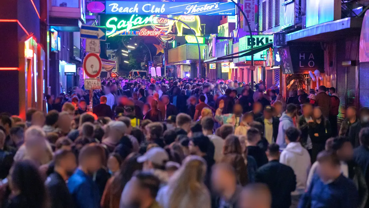 19.09.2021, Hamburg: Zahlreiche Nachtschwärmer sind auf der Großen Freiheit unterwegs. Trotz voller Straßen, Bars und Restaurants haben sich die Besucher auf der Reeperbahn am Wochenende weitgehend an die Corona-Regeln gehalten. In der Nacht zu Samstag seien in der Spitze rund 11 000 Feiernde unterwegs gewesen und in der Nacht darauf in der Spitze bis zu 25 000 Menschen, wie eine Polizeisprecherin am Sonntag in Hamburg sagte. Foto: Jonas Walzberg/dpa - ACHTUNG: Person(en) wurde(n) aus rechtlichen Gründen gepixelt +++ dpa-Bildfunk +++