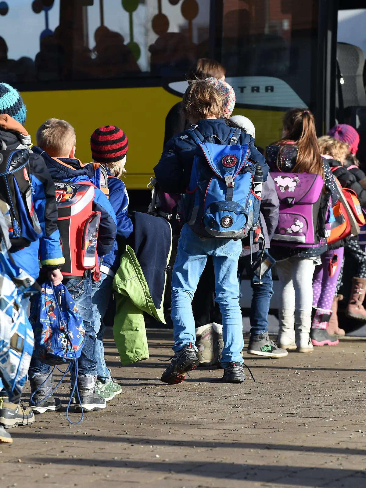 ARCHIV - 08.12.2016, Baden-Württemberg, Horgenzell: ILLUSTRATION - Mehrere Schüler steigen vor der Gemeinschaftsschule in Horgenzell (Baden-Württemberg) in einen Schulbus ein. (zu dpa: «Verwaltungsgerichtshof Baden-Württemberg veröffentlicht Urteil zu Klagen auf kostenlose Schülerbeförderung im Südwesten») Foto: Felix Kästle/dpa +++ dpa-Bildfunk +++