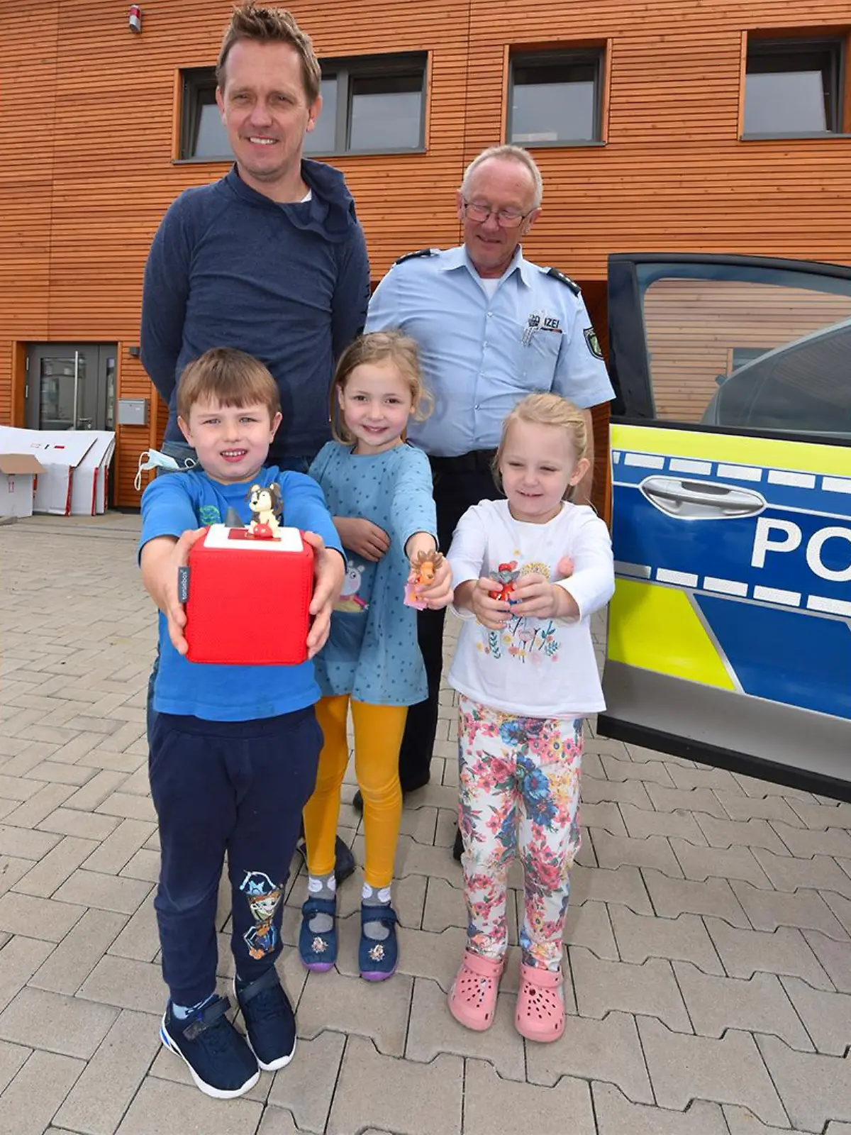 Polizeihauptkommissar Rainer Stach, der stellvertretende Leiter der Kita "Wundertüte", Marcel Rau, und drei Kinder.