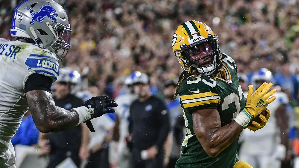 Sep 20, 2021; Green Bay, Wisconsin, USA;  Green Bay Packers running back Aaron Jones (33) runs past Detroit Lions linebacker Jamie Collins Sr. (8) to score a touchdown in the third quarter at Lambeau Field. Mandatory Credit: Benny Sieu-USA TODAY Sports
