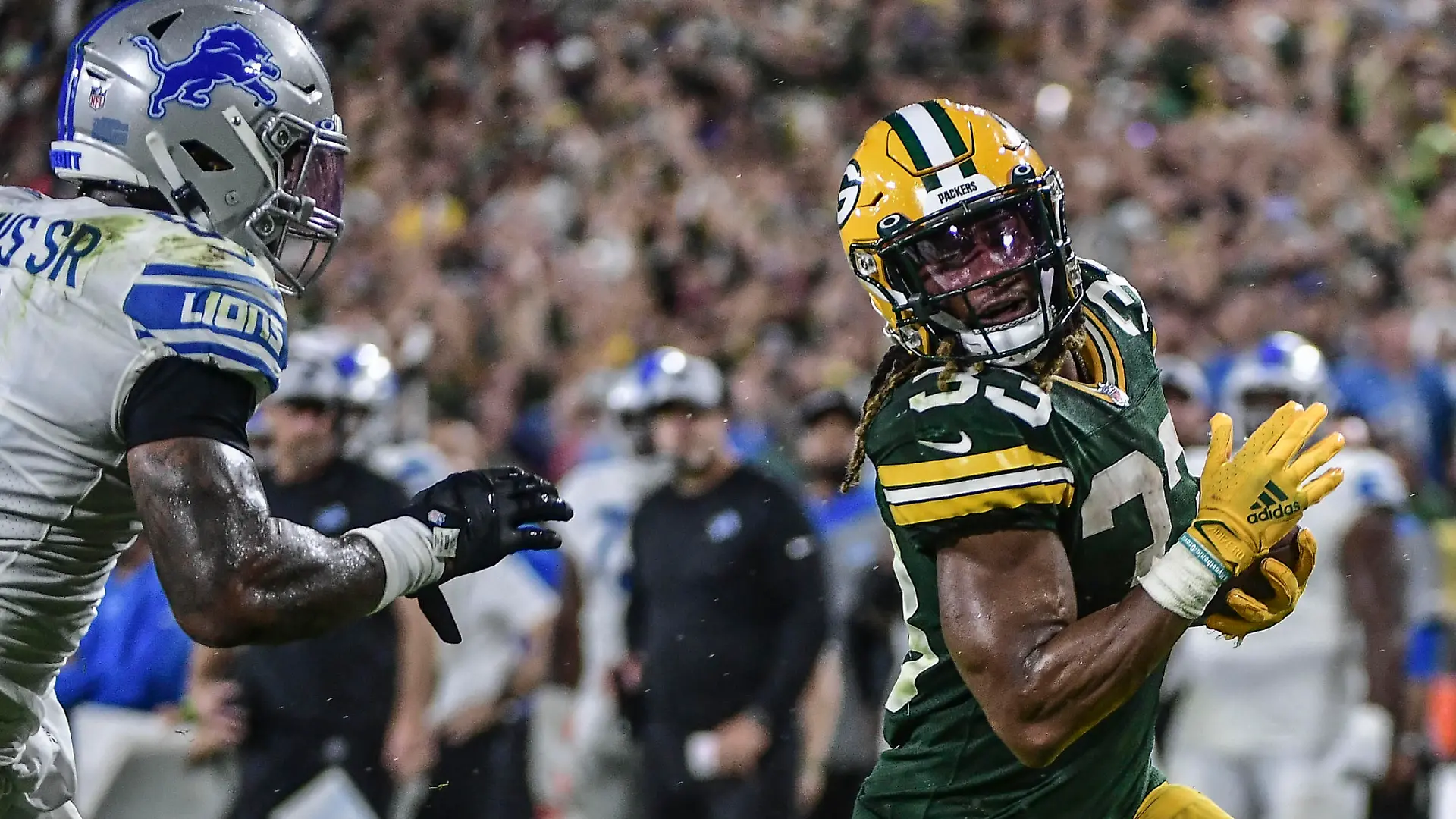 Sep 20, 2021; Green Bay, Wisconsin, USA;  Green Bay Packers running back Aaron Jones (33) runs past Detroit Lions linebacker Jamie Collins Sr. (8) to score a touchdown in the third quarter at Lambeau Field. Mandatory Credit: Benny Sieu-USA TODAY Sports