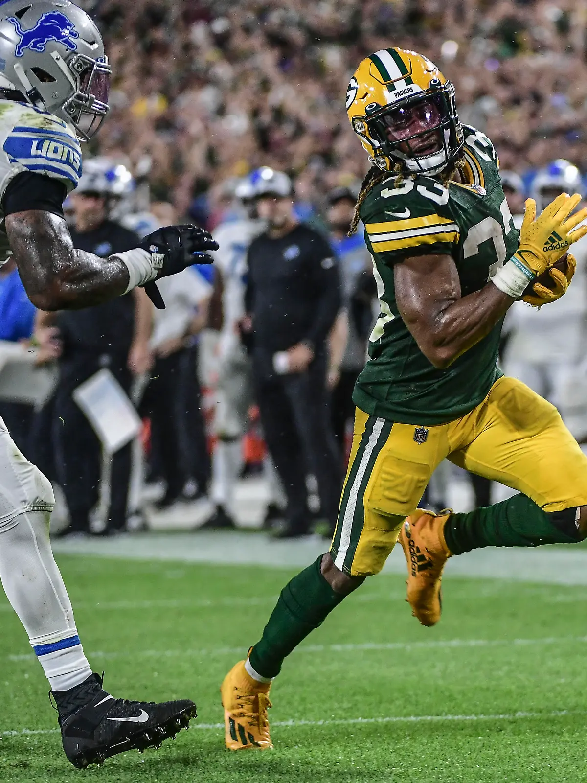 Sep 20, 2021; Green Bay, Wisconsin, USA;  Green Bay Packers running back Aaron Jones (33) runs past Detroit Lions linebacker Jamie Collins Sr. (8) to score a touchdown in the third quarter at Lambeau Field. Mandatory Credit: Benny Sieu-USA TODAY Sports