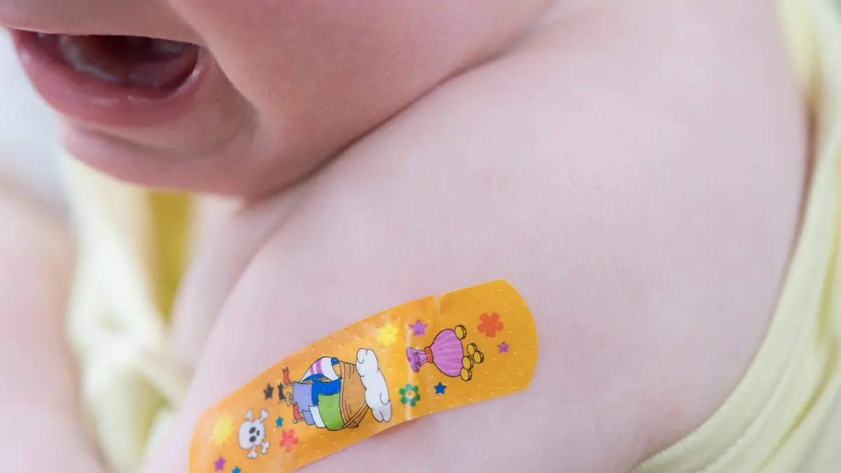 18.03.2019, Sachsen, Radeberg: Ein einjähriges Mädchen weint nach einer Kinderimpfung gegen Meningokokken und trägt ein Pflaster auf dem Arm. Foto: Sebastian Kahnert/dpa-Zentralbild/ZB