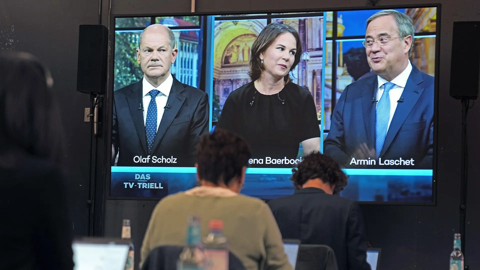 dpatopbilder - 19.09.2021, Berlin: Journalisten verfolgen im Studio H das dritte TV-Triell, die Kanzlerkandidatendiskussion bei ProSieben und Sat.1, mit Olaf Scholz (l-r), SPD-Spitzenkandidat in der Bundestagswahl und Bundesfinanzminister, Annalena Baerbock, Spitzenkandidatin von Bündnis 90/Die Grünen deren Parteivorsitzende, und Armin Laschet, Spitzenkandidat von CDU/CSU in der Bundetagswahl, CDU-Parteivorsitzender und Ministerpräsident von Nordrhein-Westfalen. Foto: Kay Nietfeld/dpa +++ dpa-Bildfunk +++