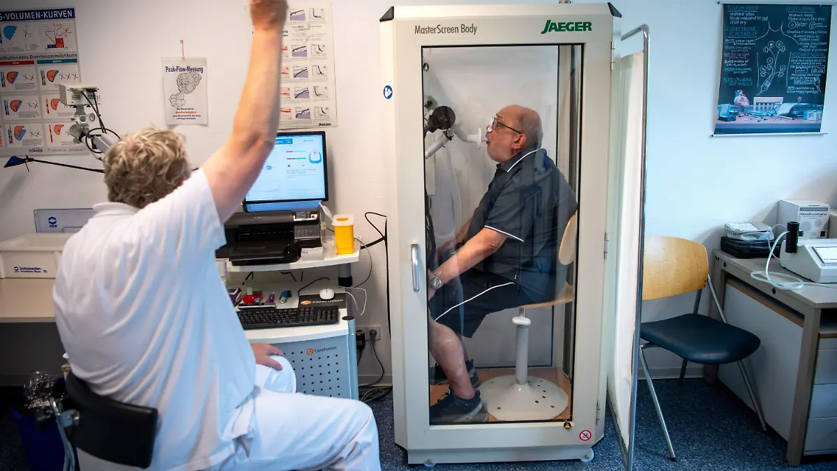 PRODUKTION - 27.07.2021, Niedersachsen, Bad Rothenfelde: Reinhard Janzen sitzt zur Überprüfung seiner Lungenfunktion in einem Bodyplethysmographen. In der Klinik am Teutoburger Wald werden Long-Covid-Patienten behandelt. (zu dpa «Aus dem Leben geworfen - Reha für Menschen mit Long Covid») Foto: Sina Schuldt/dpa +++ dpa-Bildfunk +++