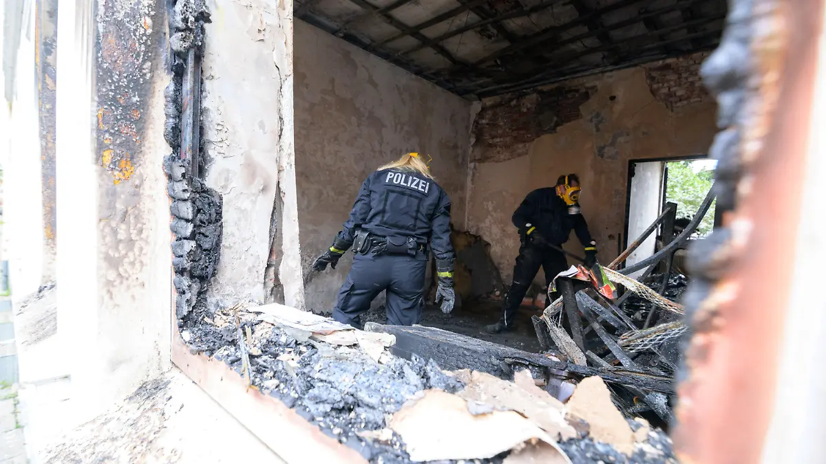 19.09.2021, Hamburg: Zwei Brandermittler der Polizei arbeiten in der zerstörten Brandwohnung. Bei einem Wohnungsbrand in Hamburg-Harburg sind am frühen Sonntagmorgen zwei Menschen ums Leben gekommen. Eine weitere Person sei lebensgefährlich verletzt worden, sagte ein Sprecher der Feuerwehr. Foto: Jonas Walzberg/dpa +++ dpa-Bildfunk +++