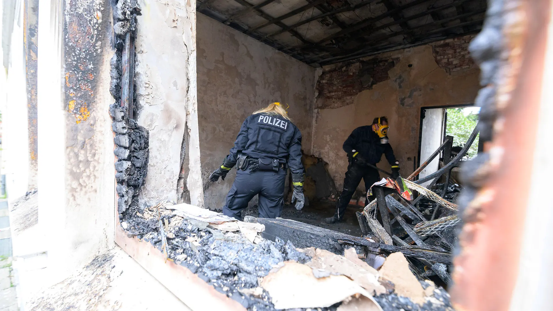 19.09.2021, Hamburg: Zwei Brandermittler der Polizei arbeiten in der zerstörten Brandwohnung. Bei einem Wohnungsbrand in Hamburg-Harburg sind am frühen Sonntagmorgen zwei Menschen ums Leben gekommen. Eine weitere Person sei lebensgefährlich verletzt worden, sagte ein Sprecher der Feuerwehr. Foto: Jonas Walzberg/dpa +++ dpa-Bildfunk +++